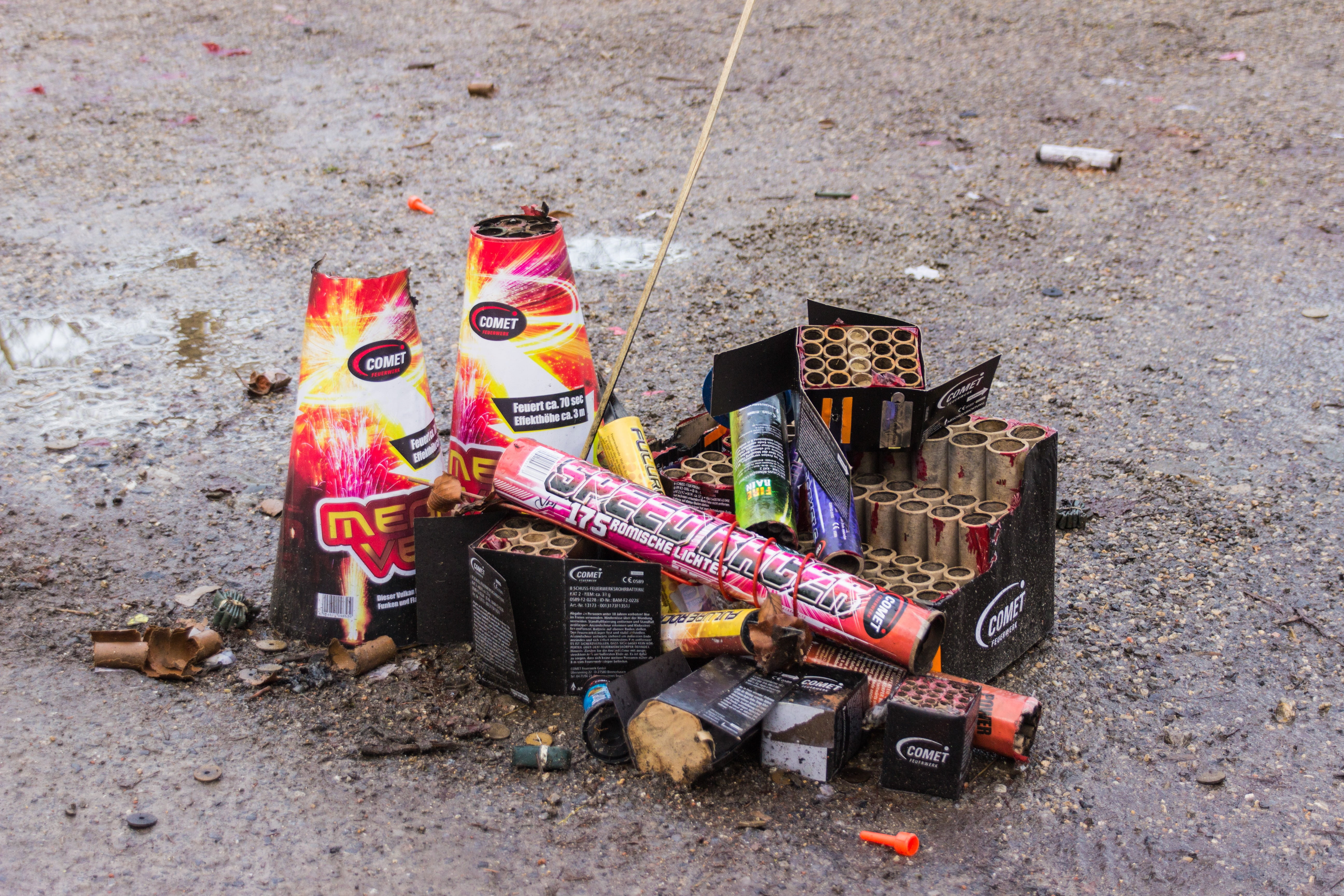 assorted fireworks boxes on gray pavement at daytime, pyrotechnics