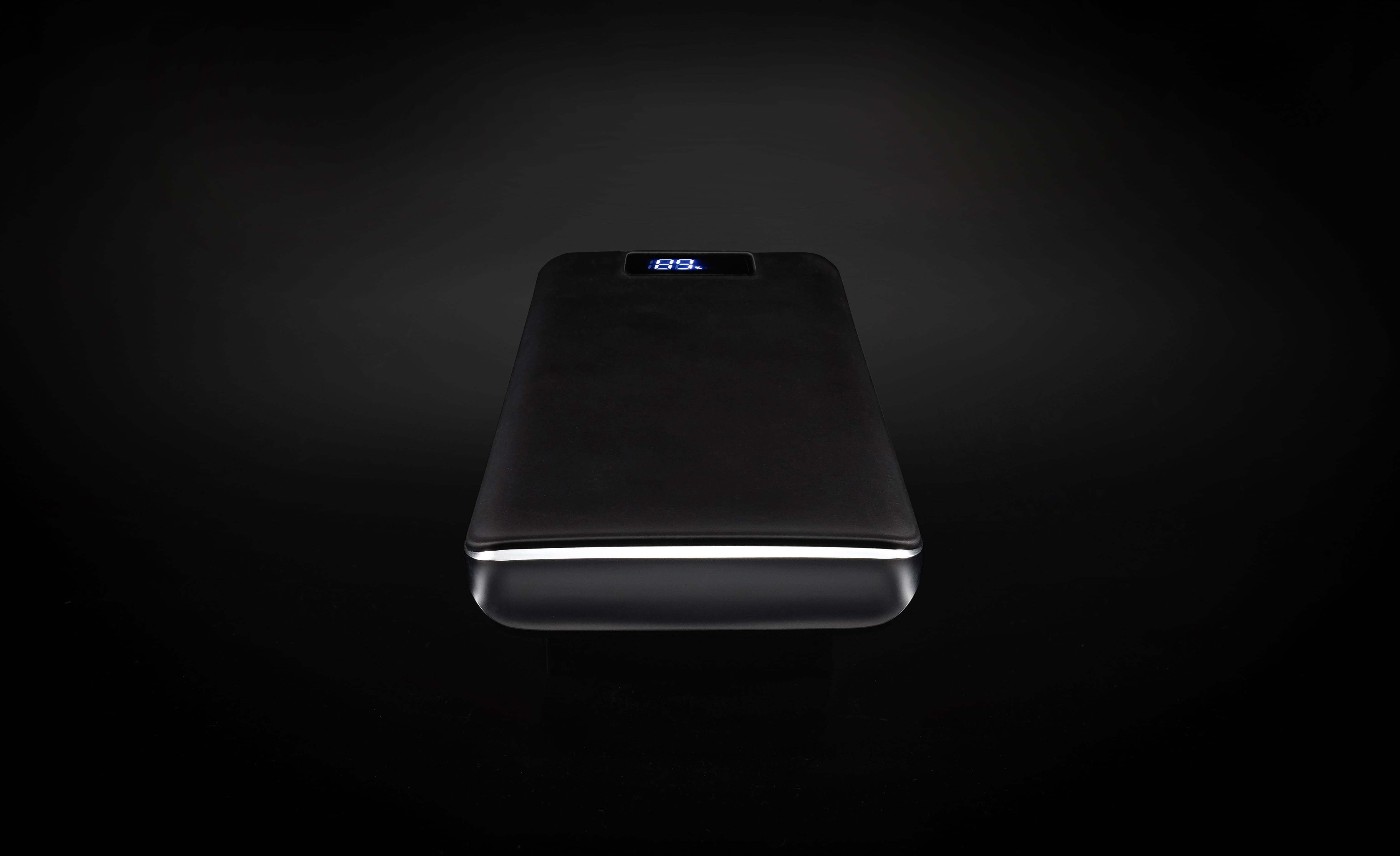 black power bank turned on, black power bank with black background