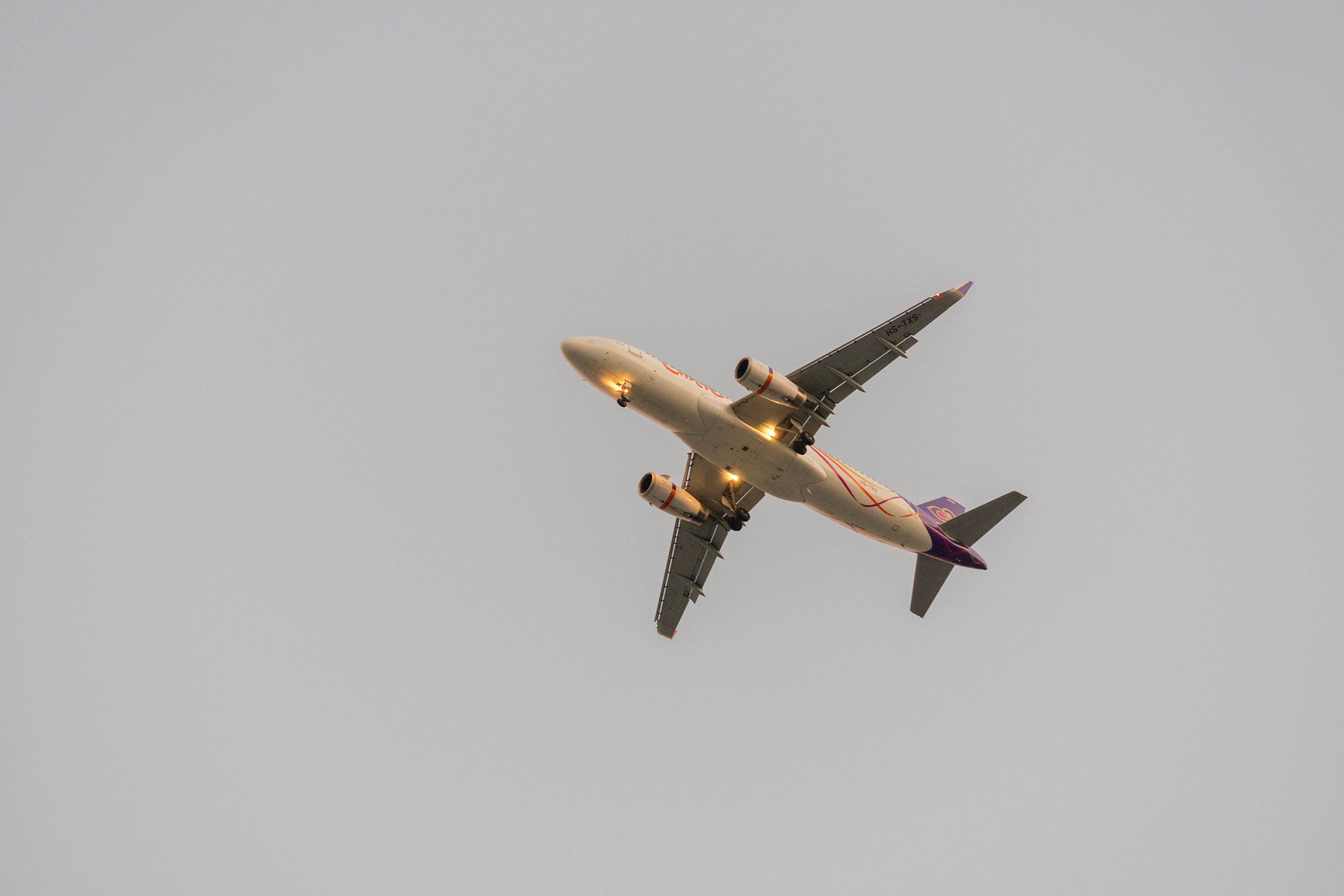 beige and red airplane under gray skies, flying, flight, travel