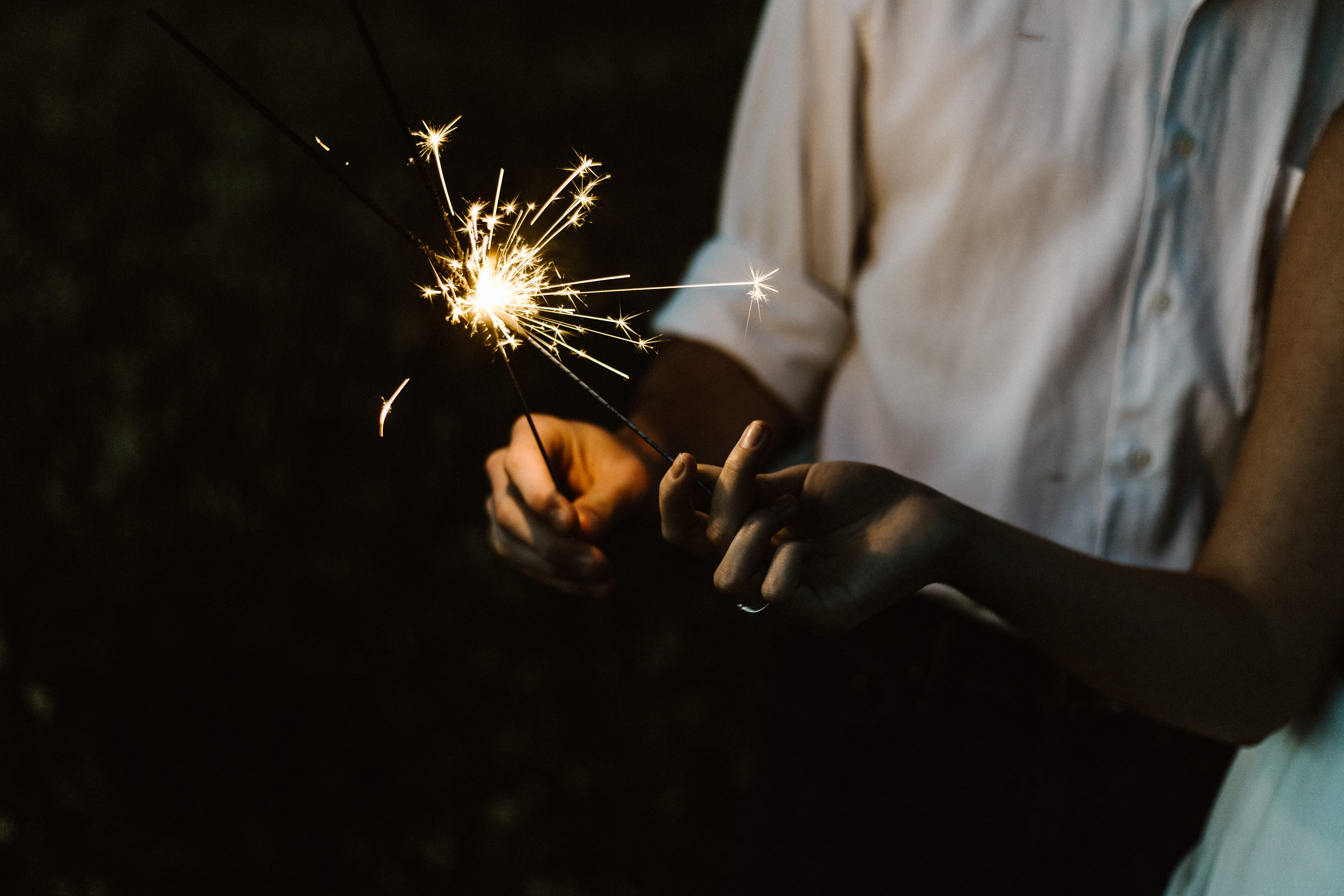 two person holding sparklers, person holding sparklers, celebration