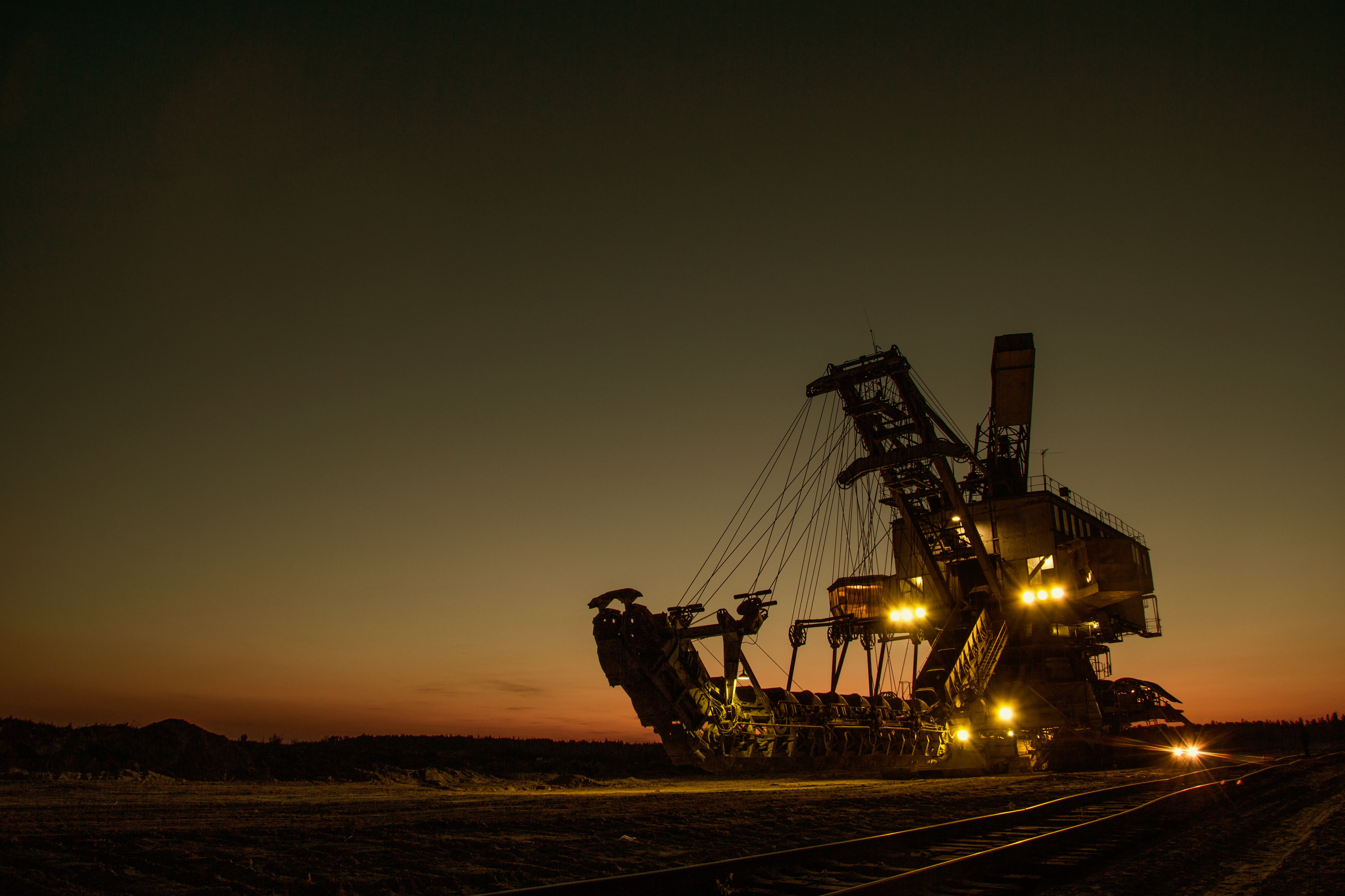 brown heavy machinery with lights during golden hour, mining excavator