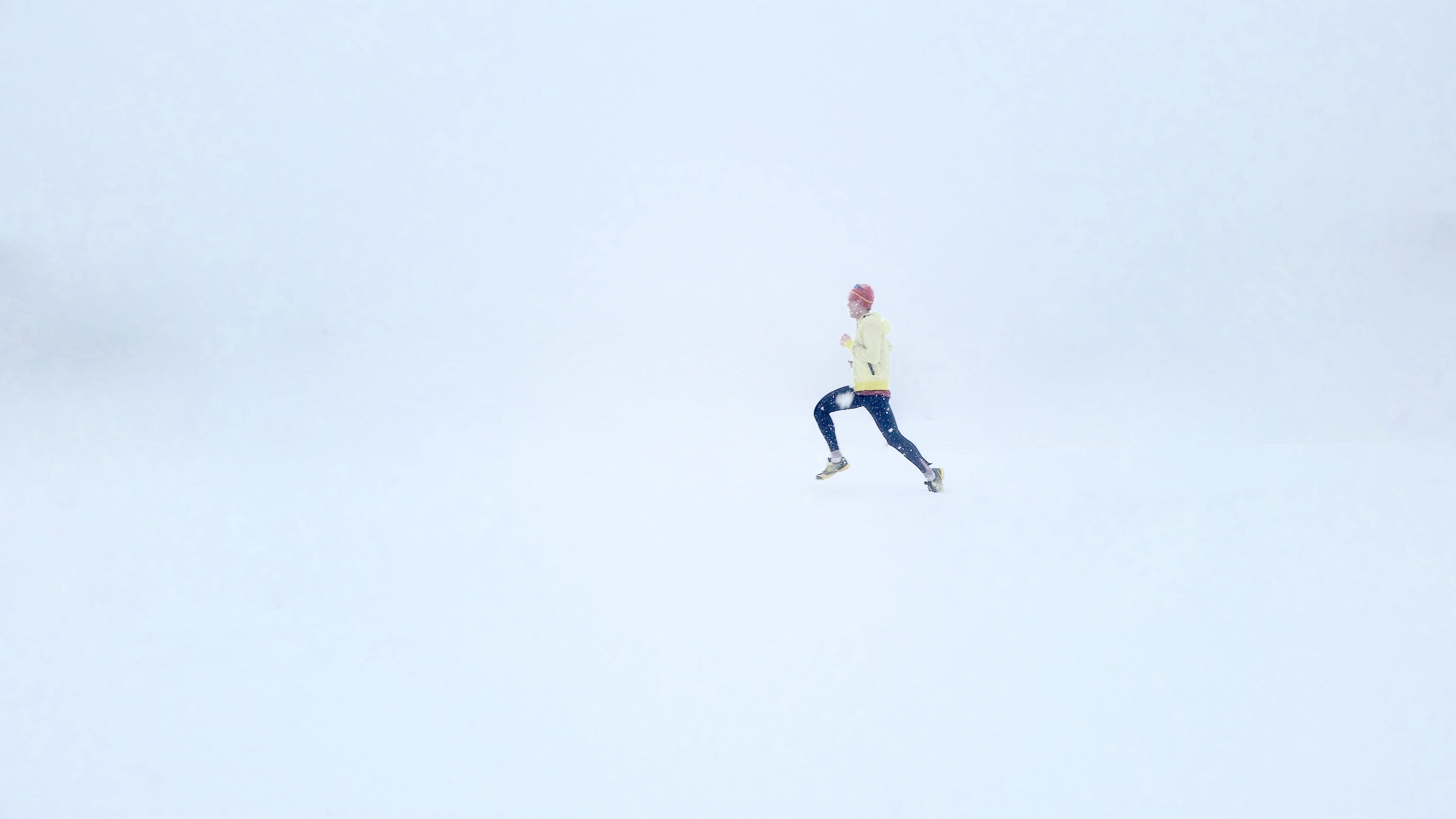person wearing yellow jacket and black pants, person in yellow sweatshirt and black pants running in white room