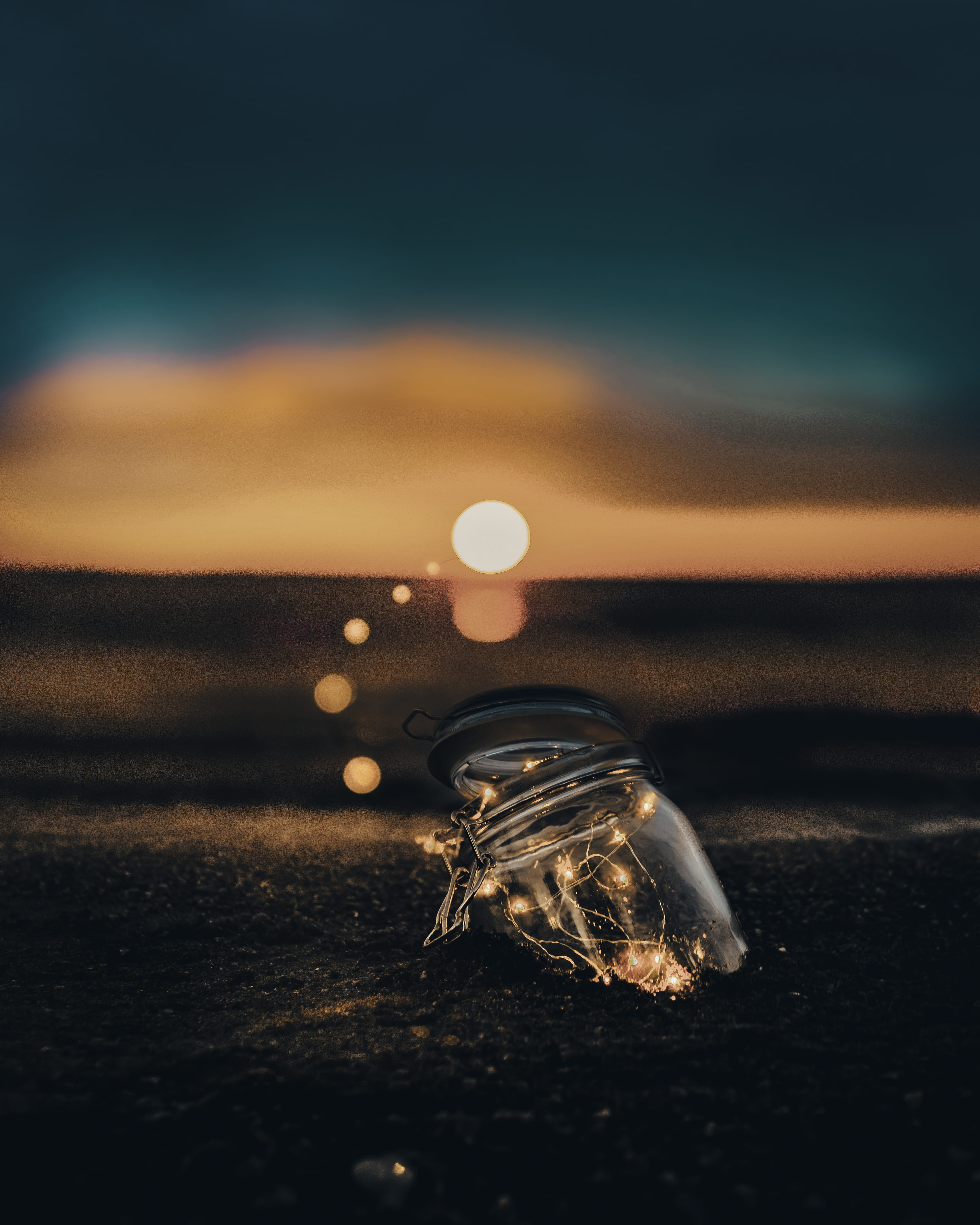 clear glass jar on sand, capture the light, fairy light, mason jar
