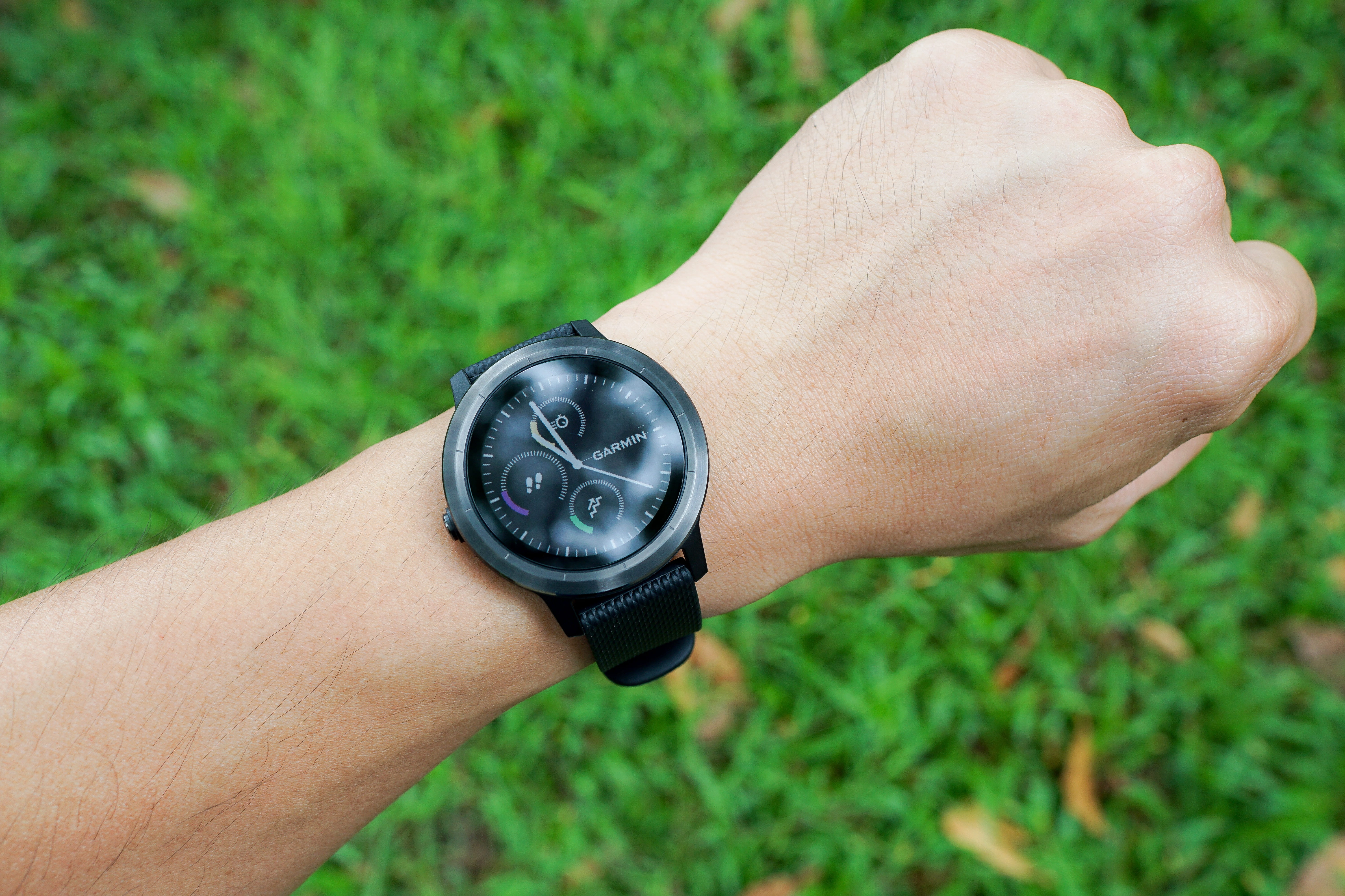 person wearing round black chronograph watch at 10:59, smartwatch