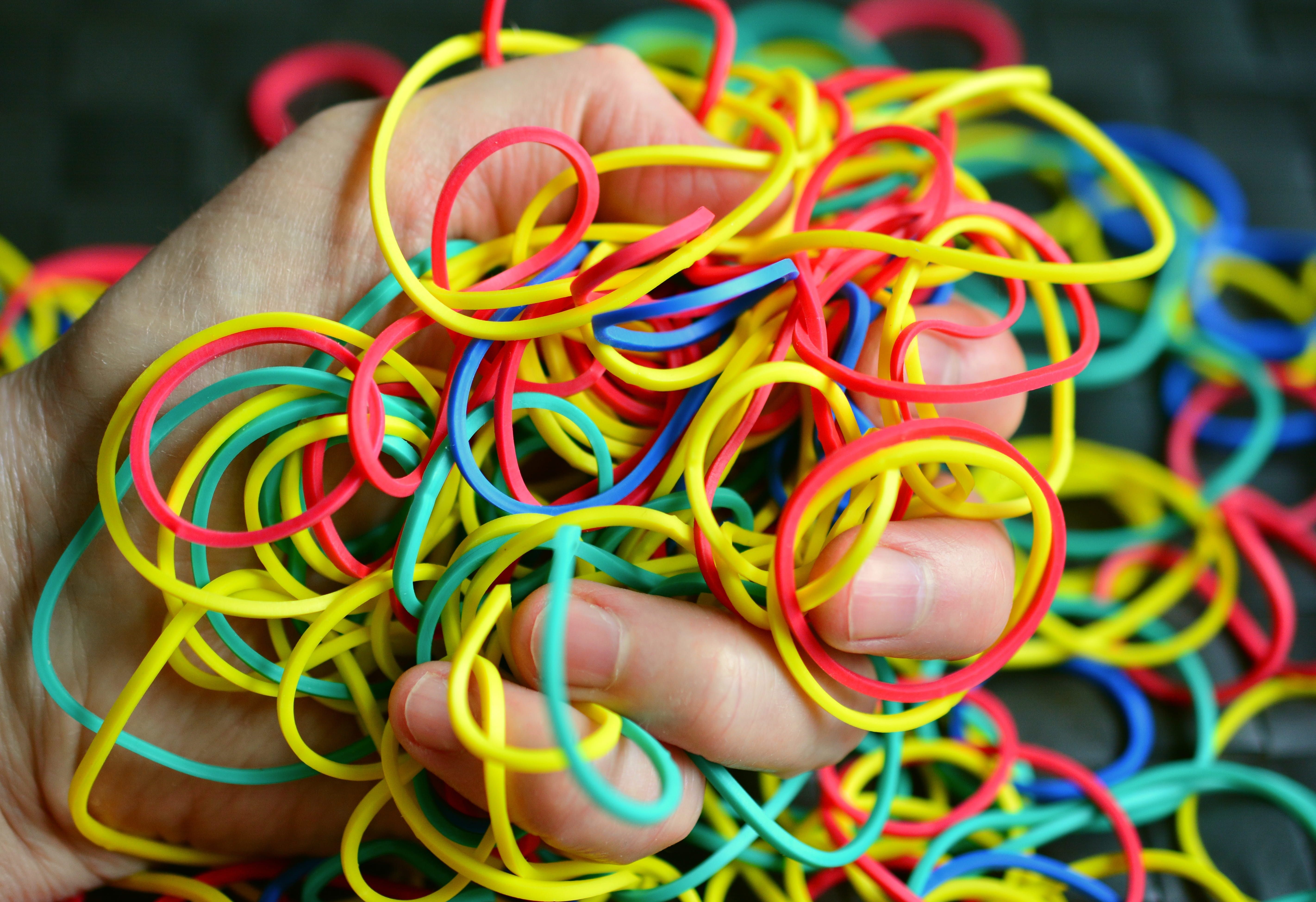 person holding assorted-colored loombands, Rubber, Rings, Hand