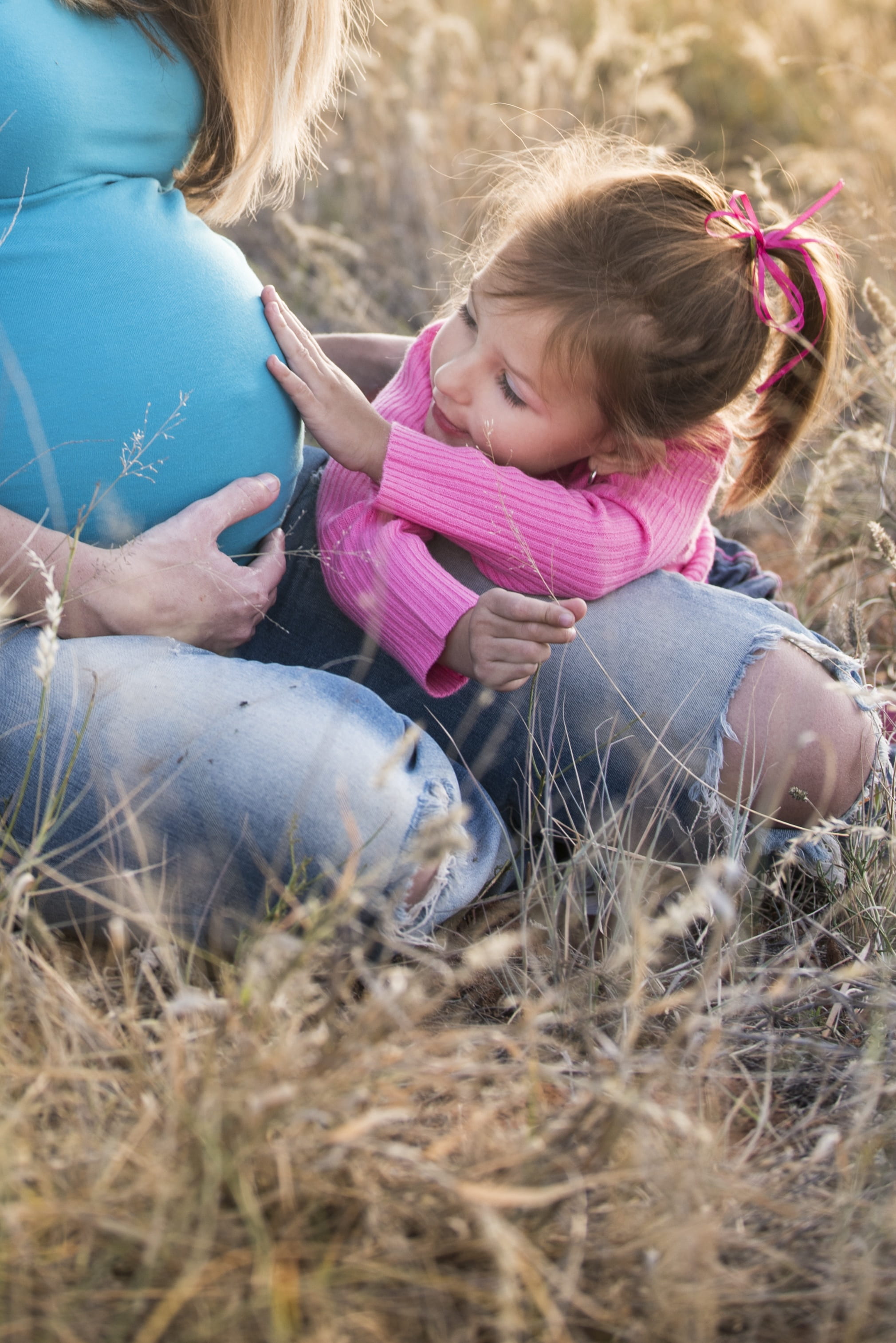 photo of girl touching pregnant woman's womb, pregnant belly