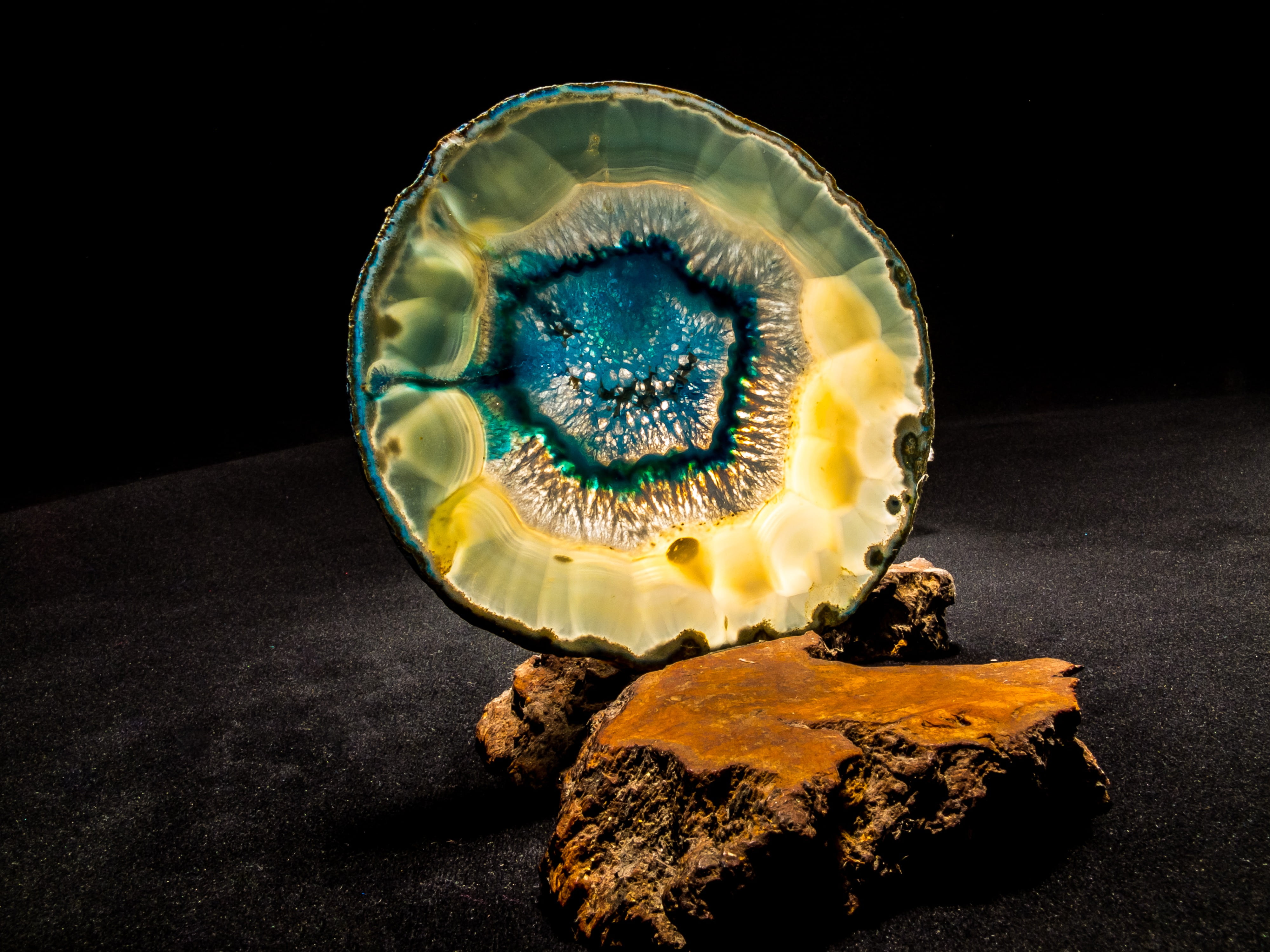 blue and brown geode on brown rock, agate slice, close, light