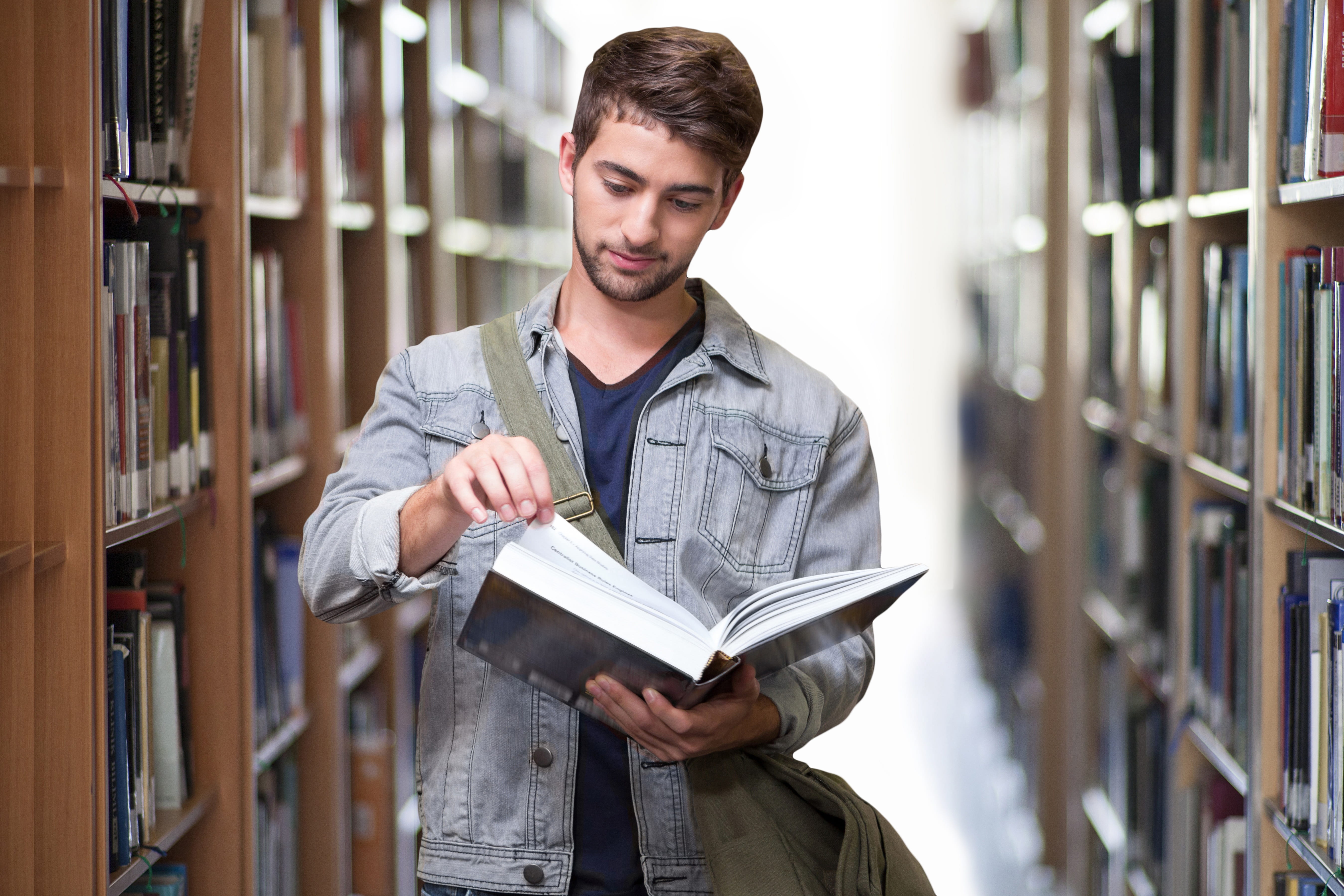 man holding a book inside library, student, books, learn, education