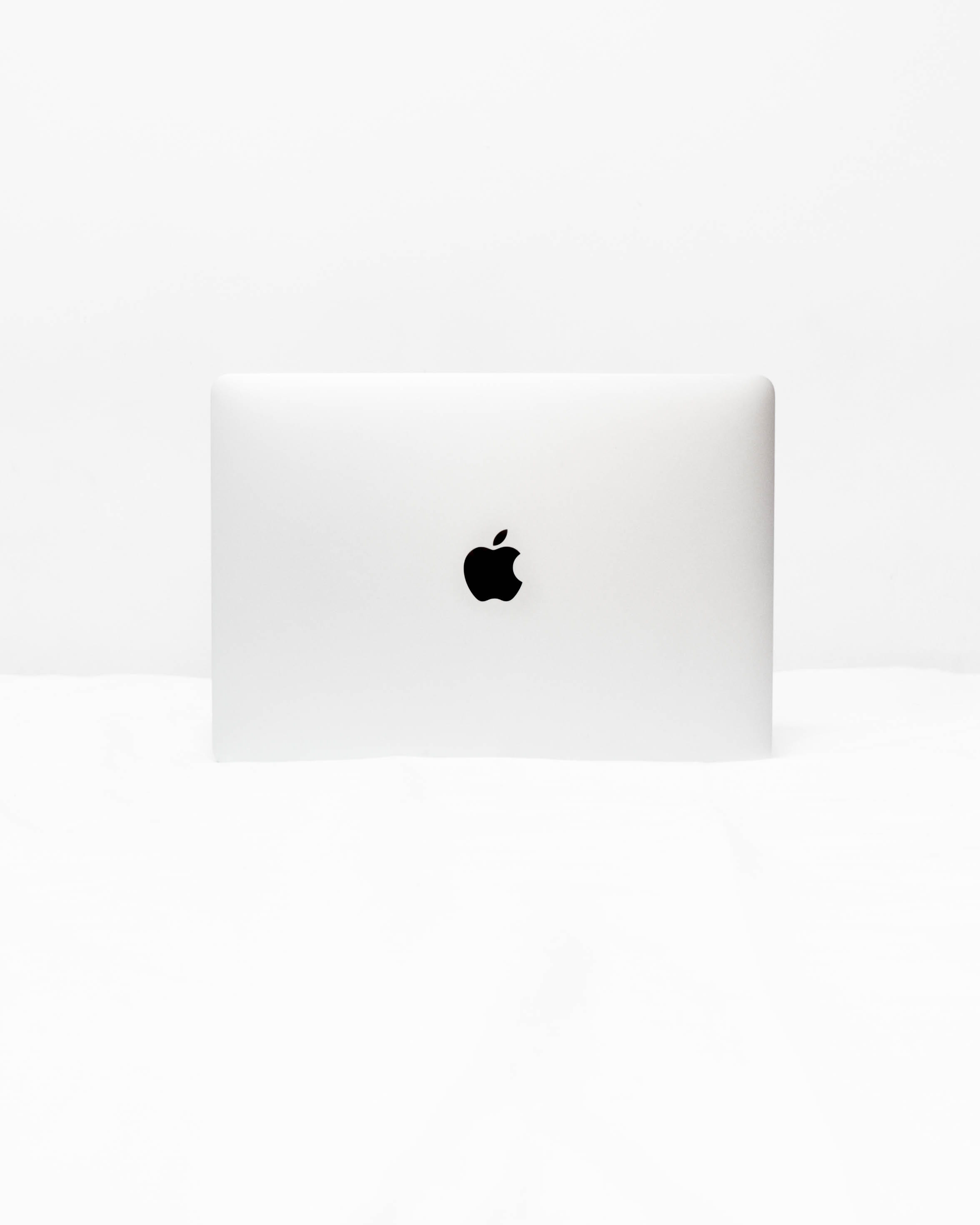 MacBook White open on white surface, silver Apple MacBook on white surface