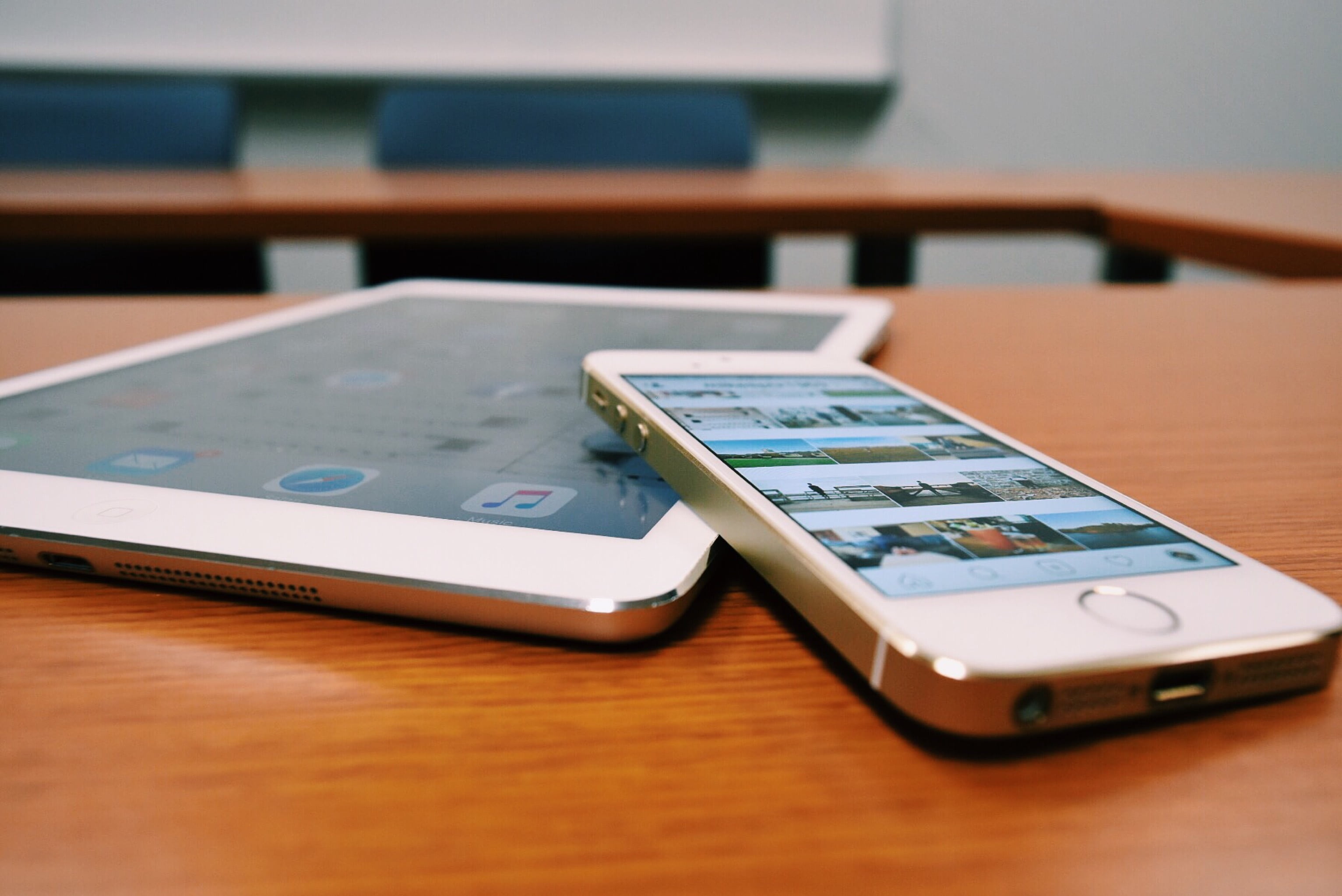 silver iPhone 5s resting on iPad on table, desk, tablet, device