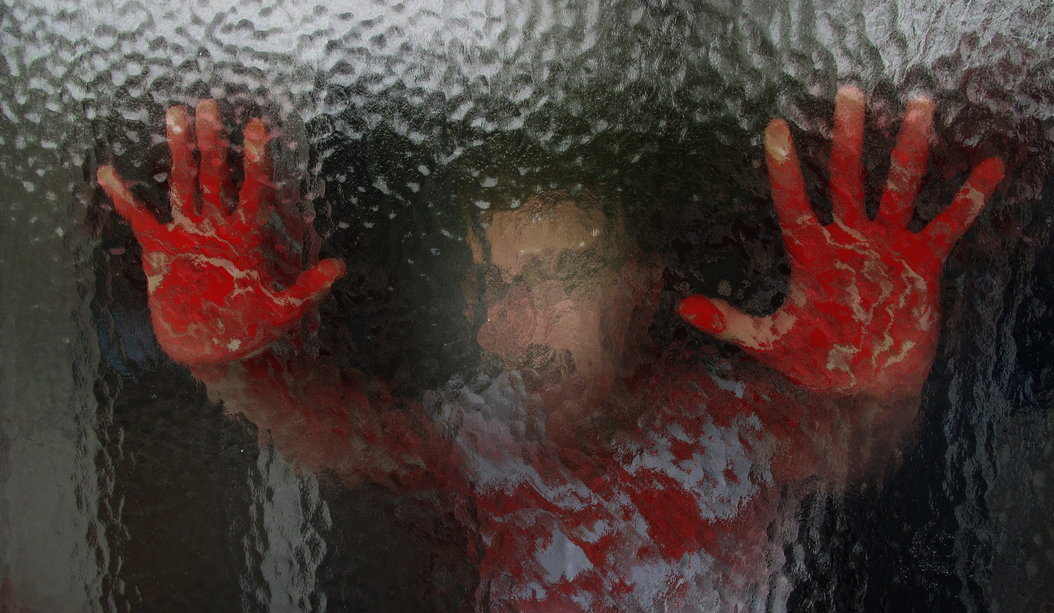 person holding glass with bloody hands, glass wall, frosted glass