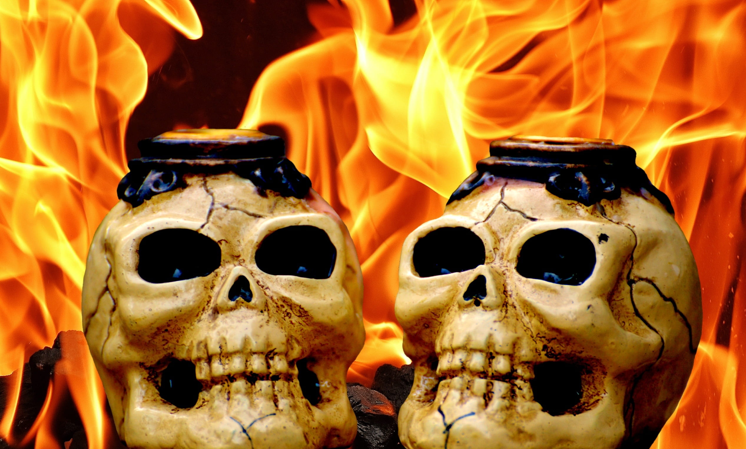 two human skull decors near flame, skull and crossbones, creepy