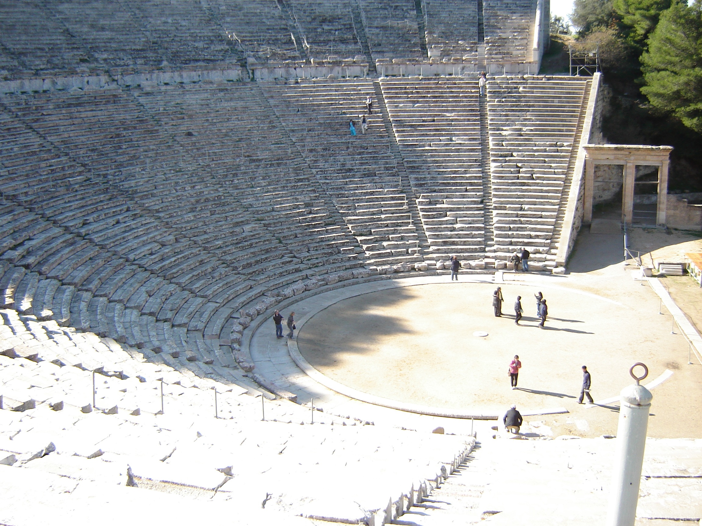 group of people stand on half-circle coliseum, epidaurus, amphitheater