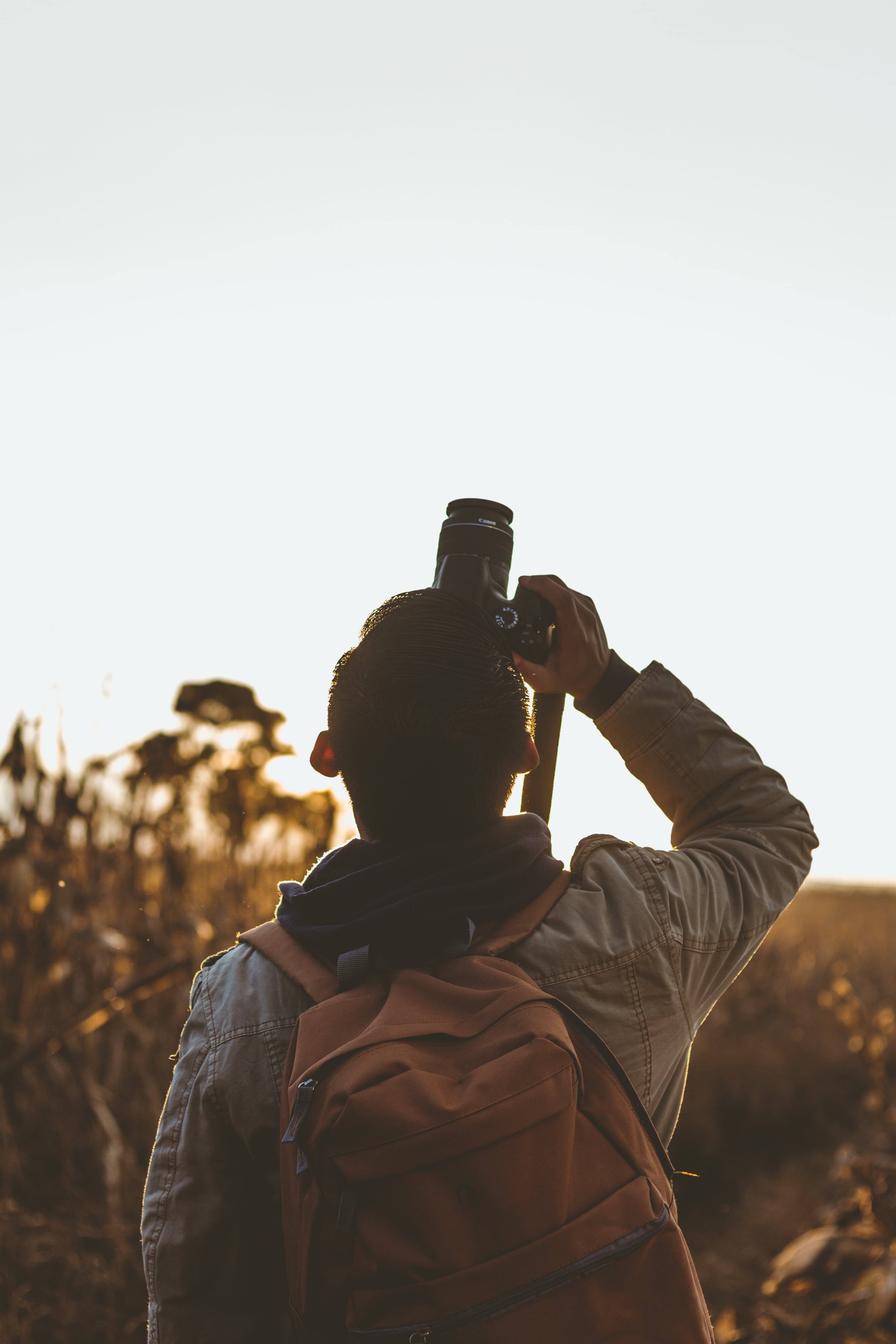 man holding DSLR camera taking photo upwards, guy, capture, shooting