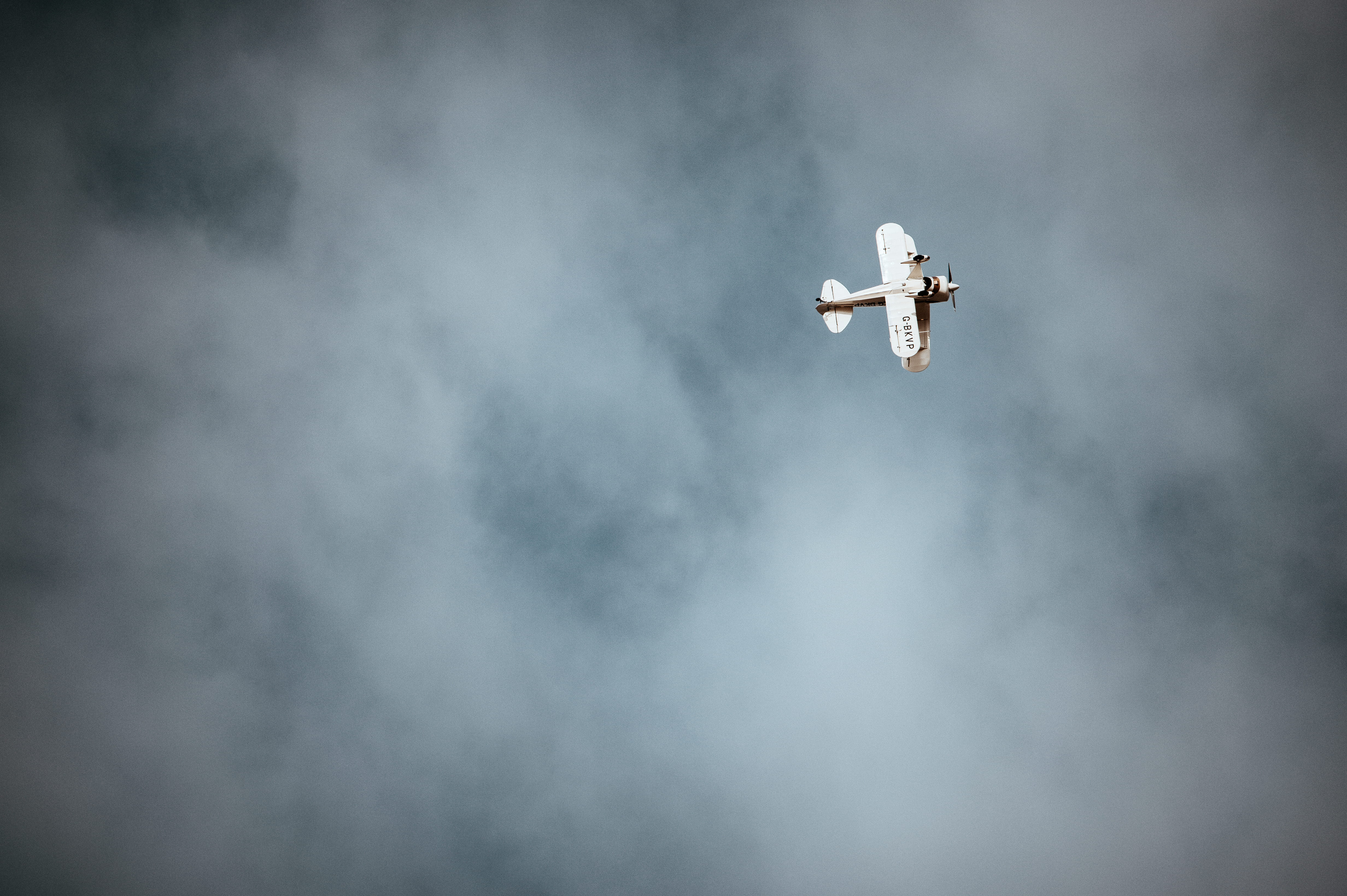 white monoplane on sky, smoke - physical structure, cloud - sky