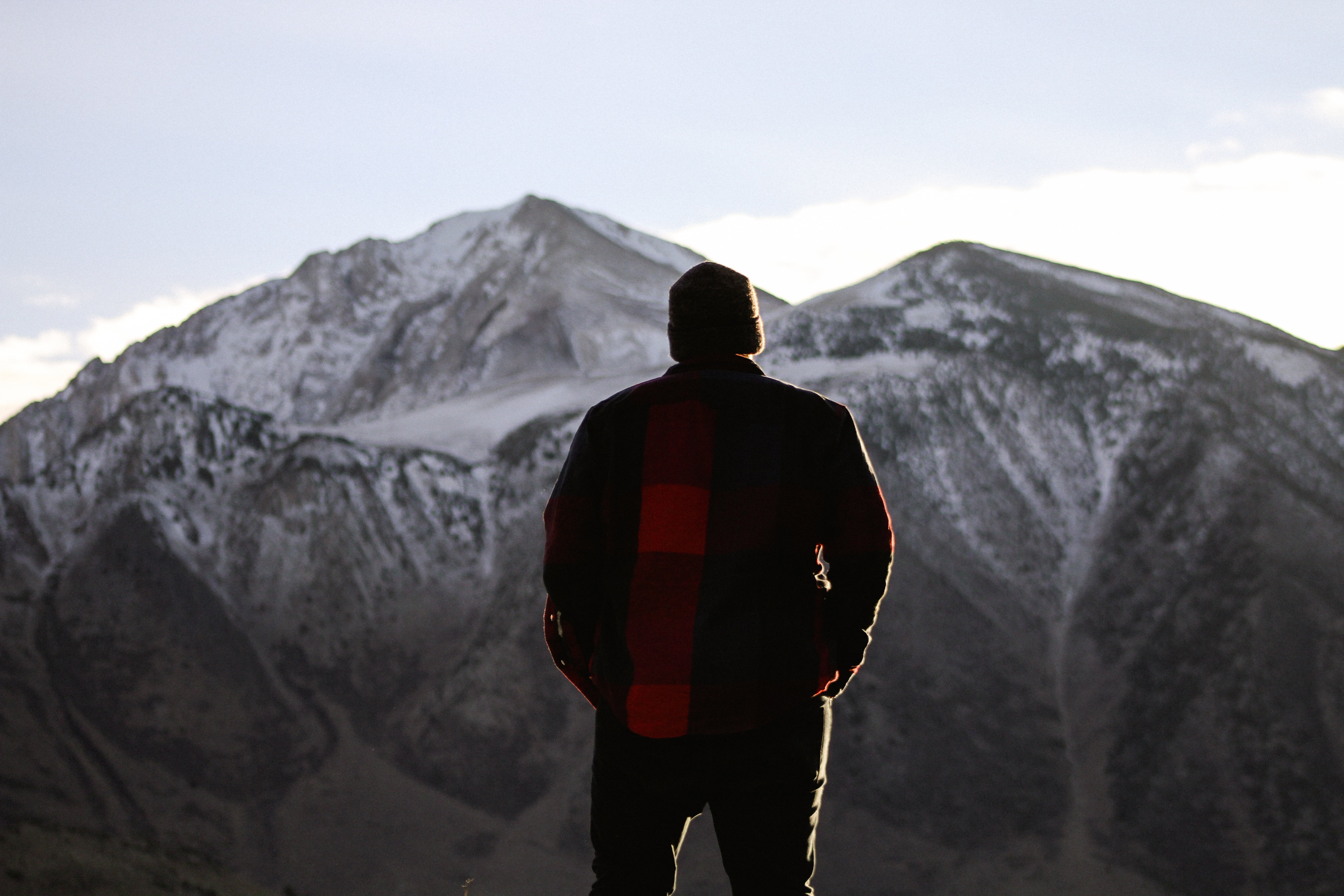 man standing on ground and facing at mountains, people, alone