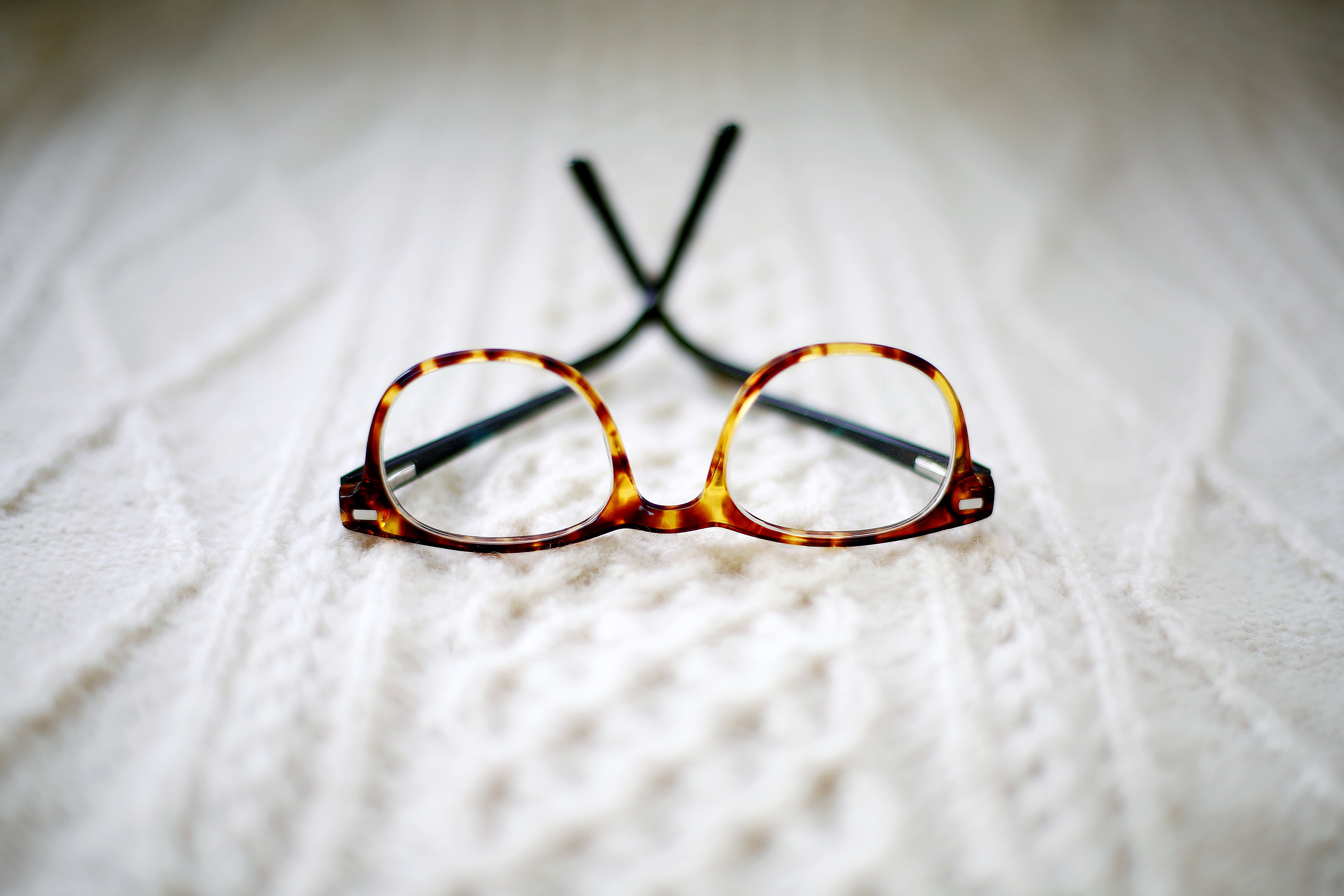 brown framed eyeglasses placed cushion, blur, bed, eyesight, eye test equipment