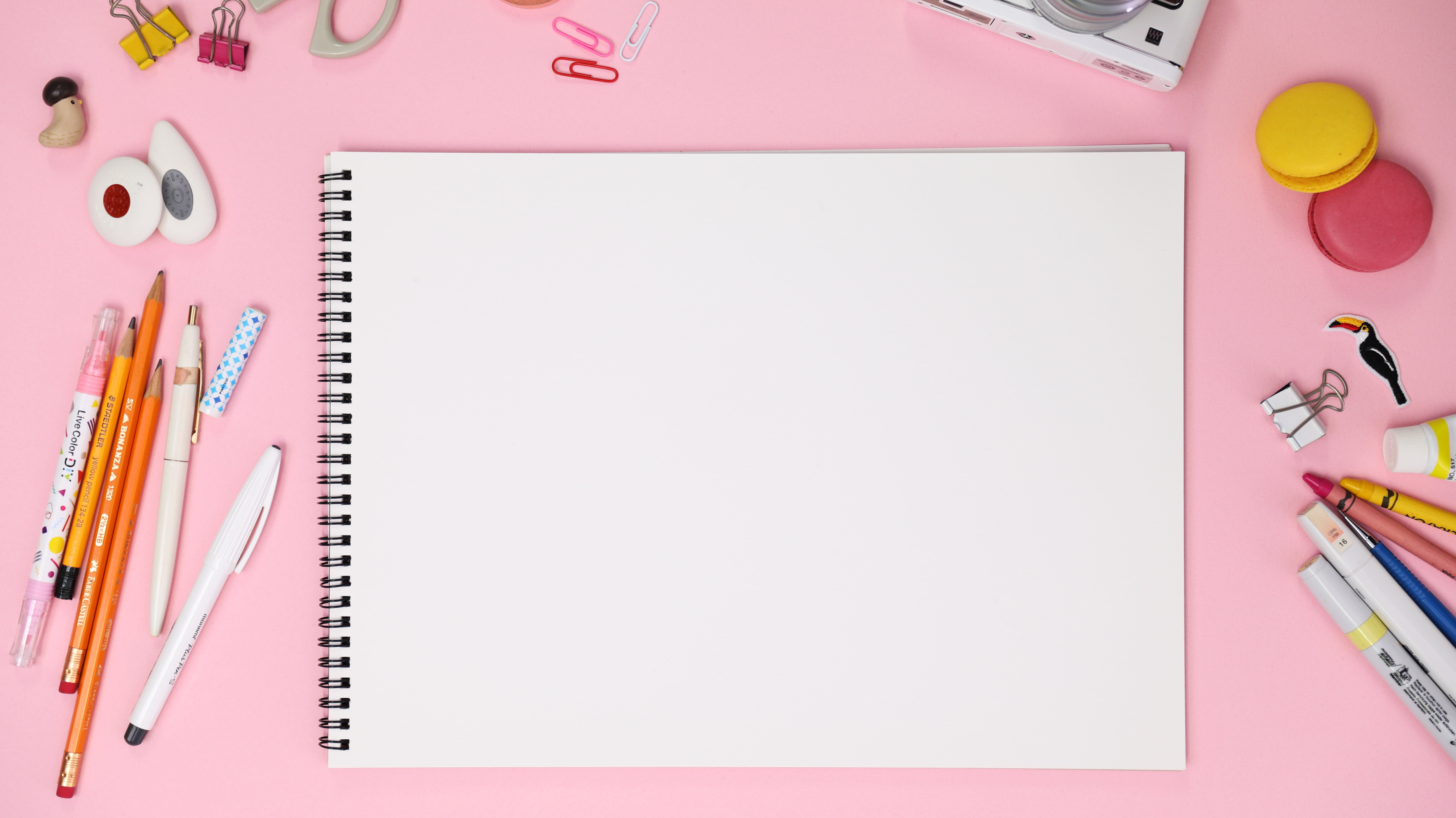 white notepad between color pens, pink, macaroon, sketchbook