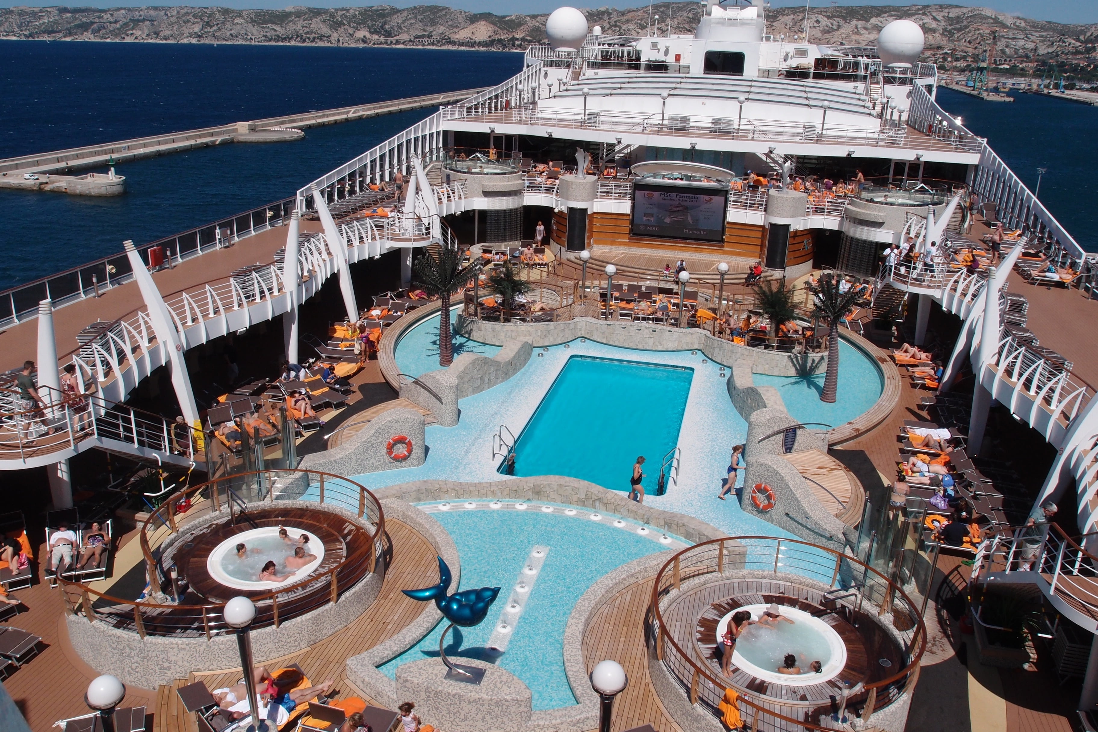 people on cruise ship with swimming pool during daytime, luxury