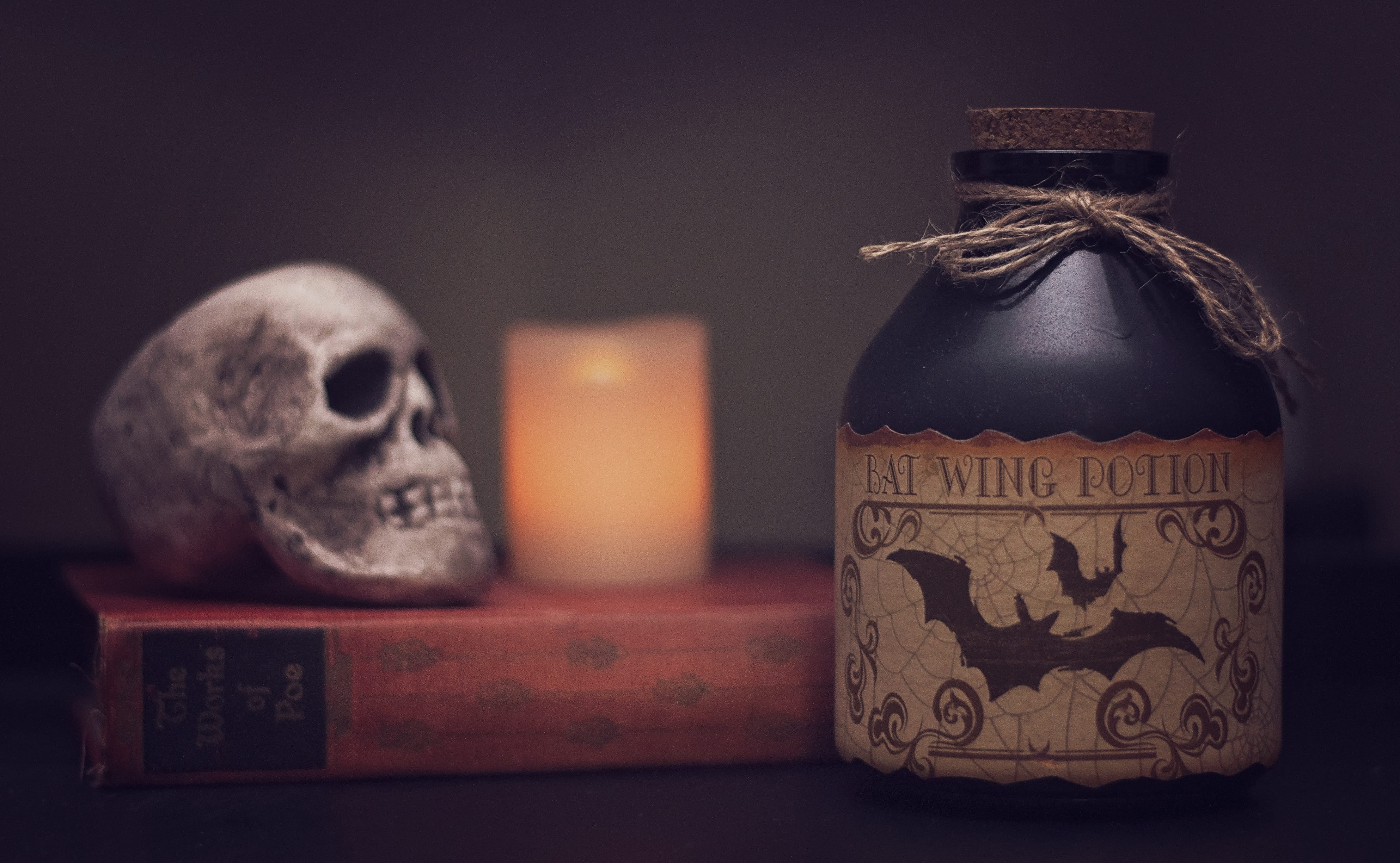 Bat Wing Potion bottle near bottle and skull, poison, halloween