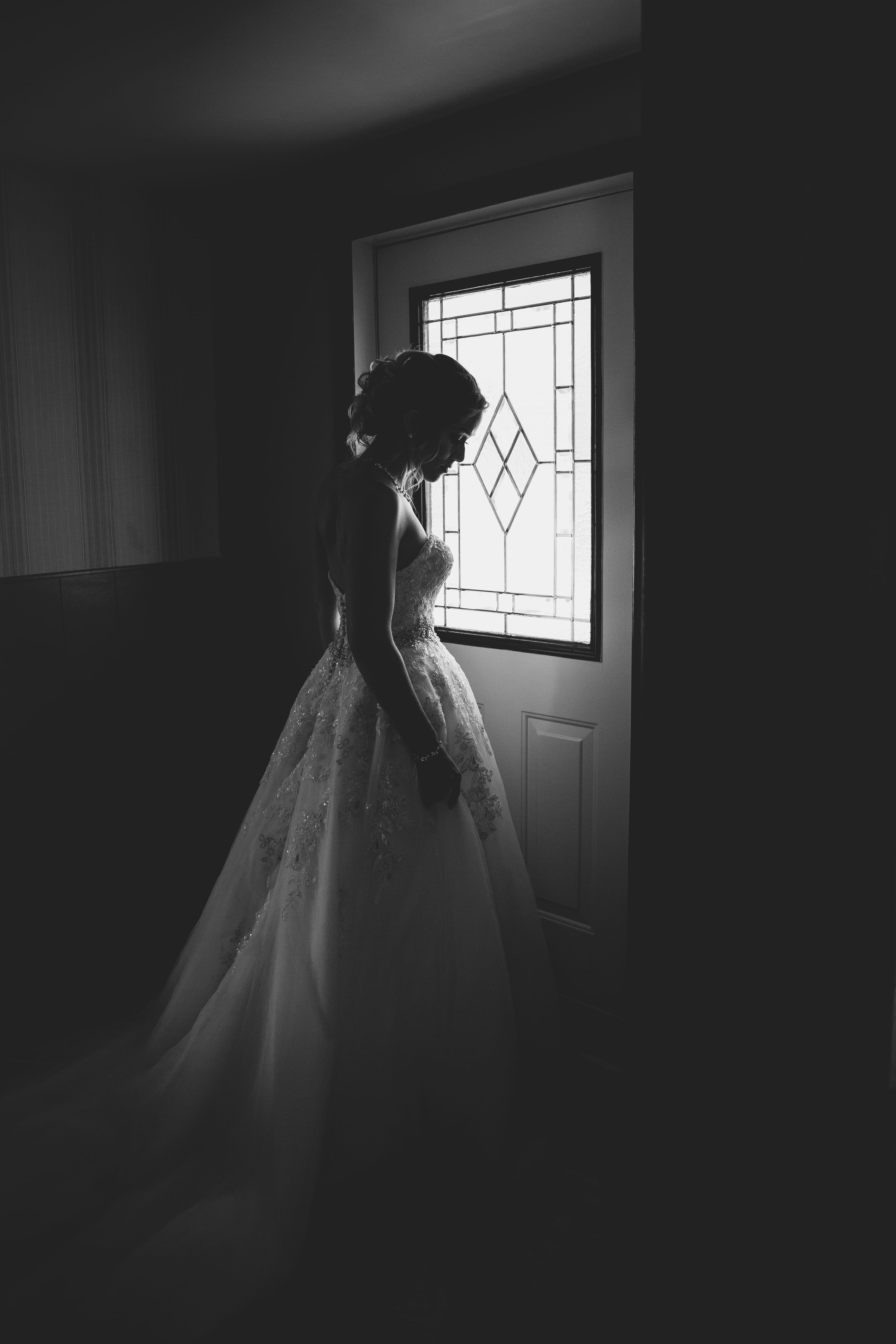 woman standing behind the door, woman in wedding gown, bride