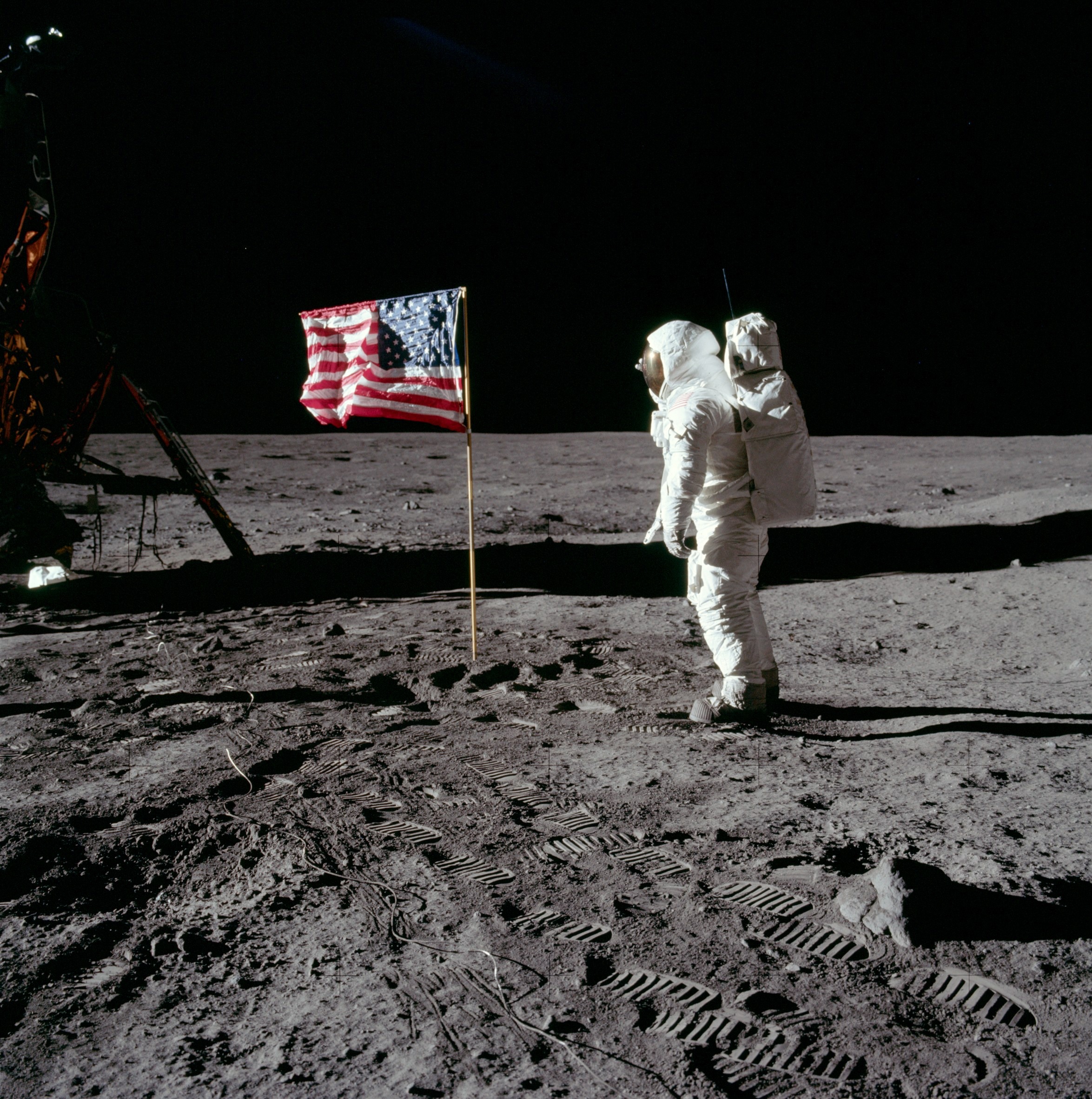 astronaut on moon in front of American flag photo, moon landing