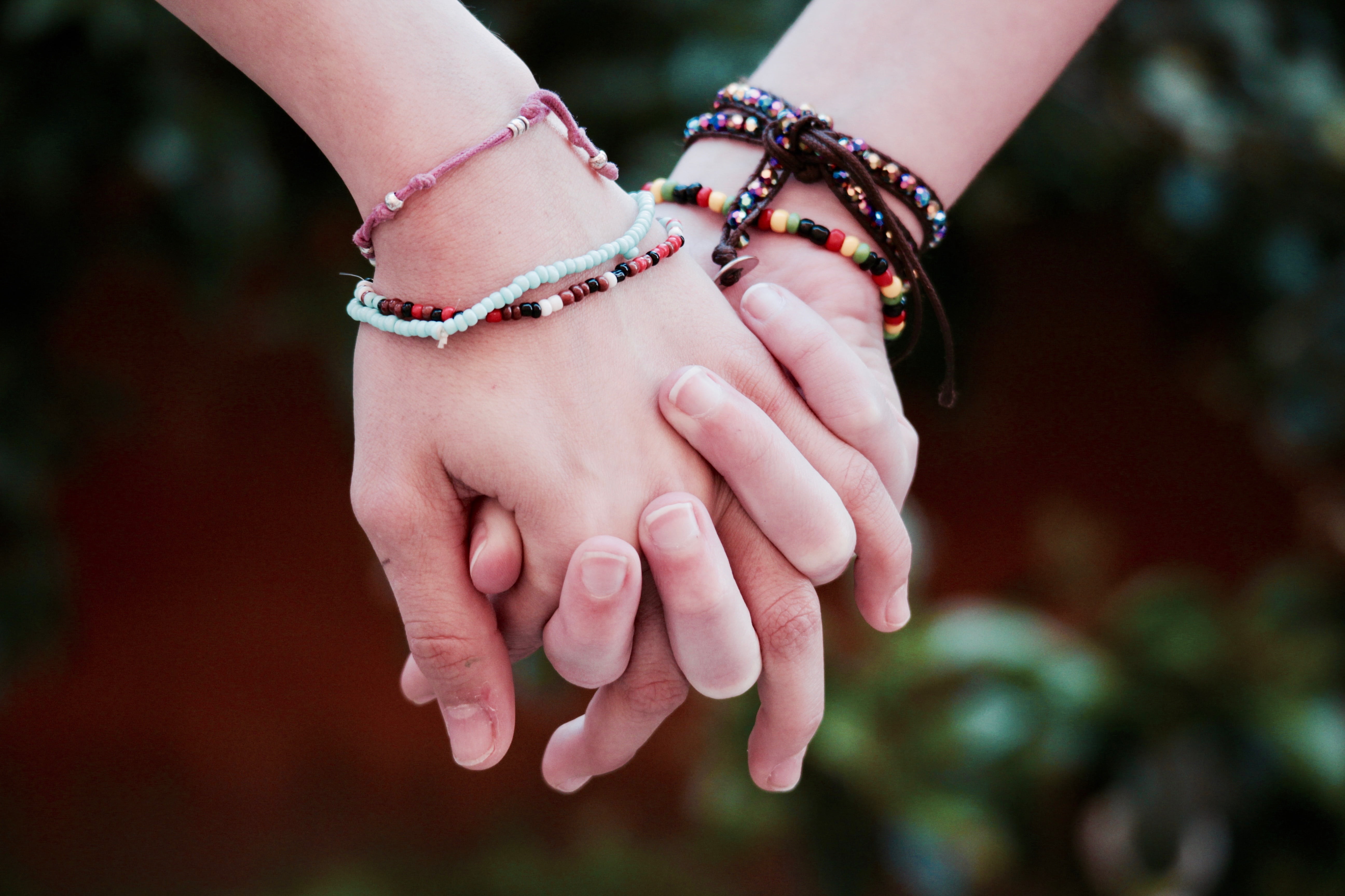 person's wearing multi-colored friendship bracelets, brotherhood