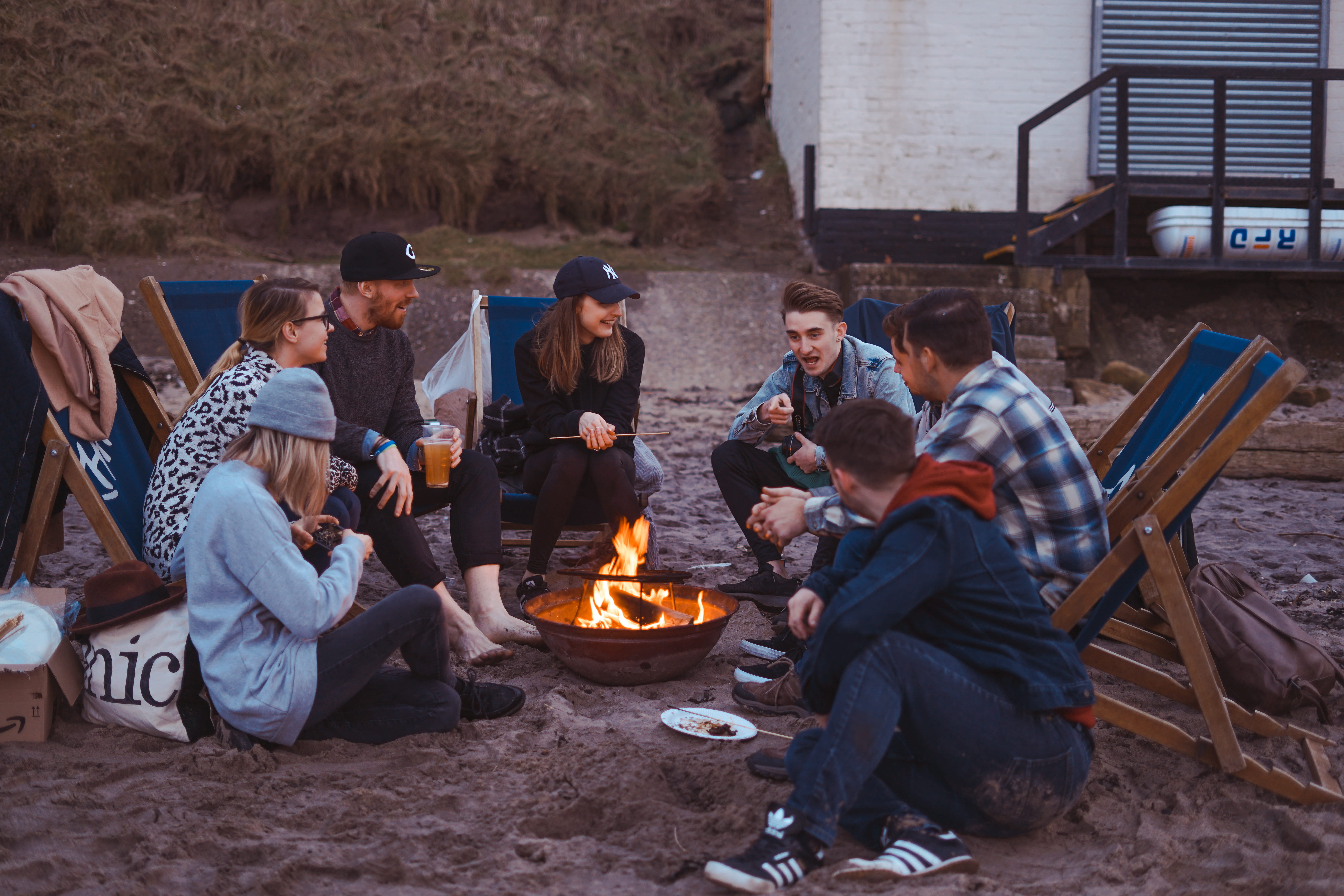 group of people sitting on front firepit, group of people surrounding fire pit