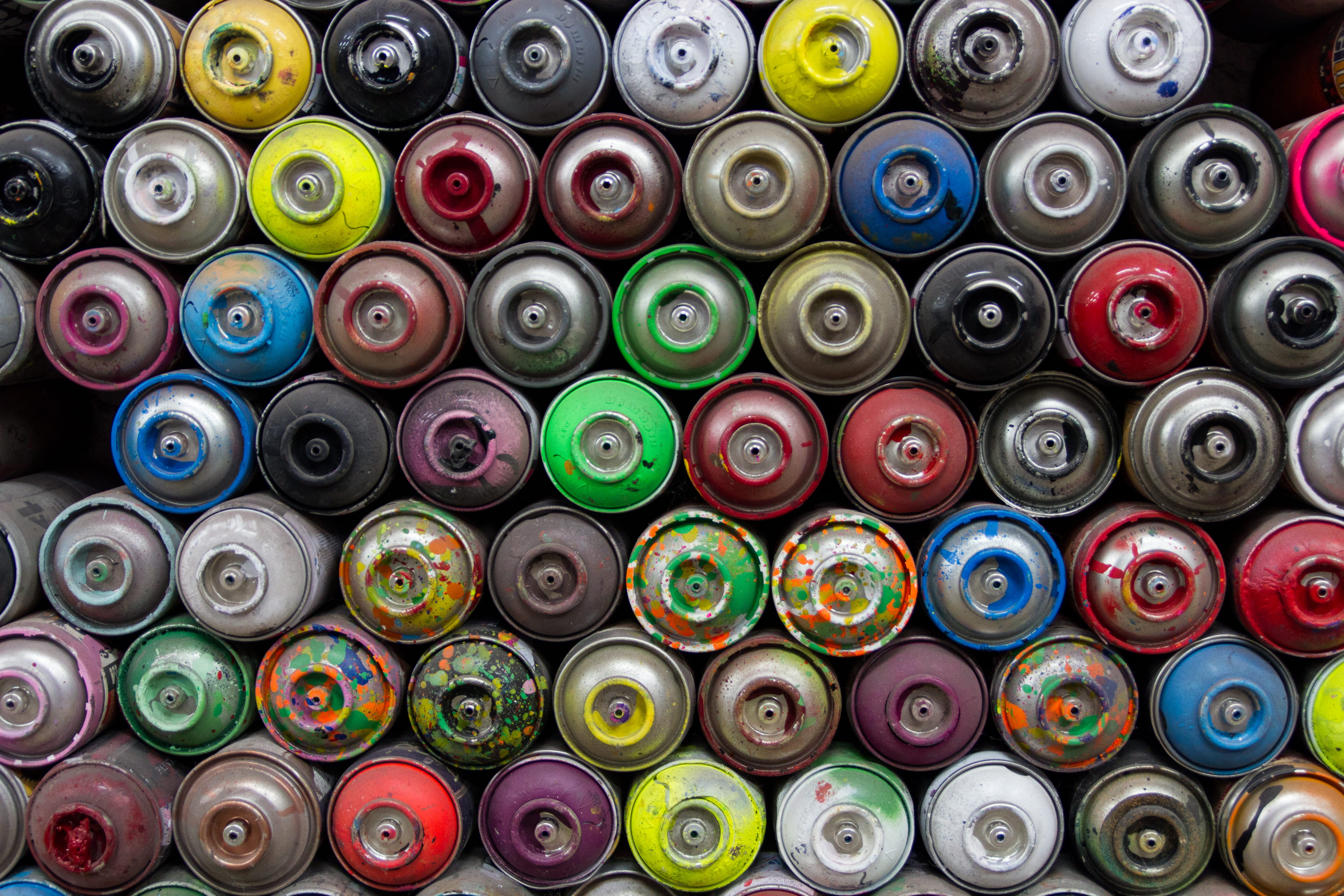 pile of butane can, assorted spray bottles, paint, colorful, spraycan