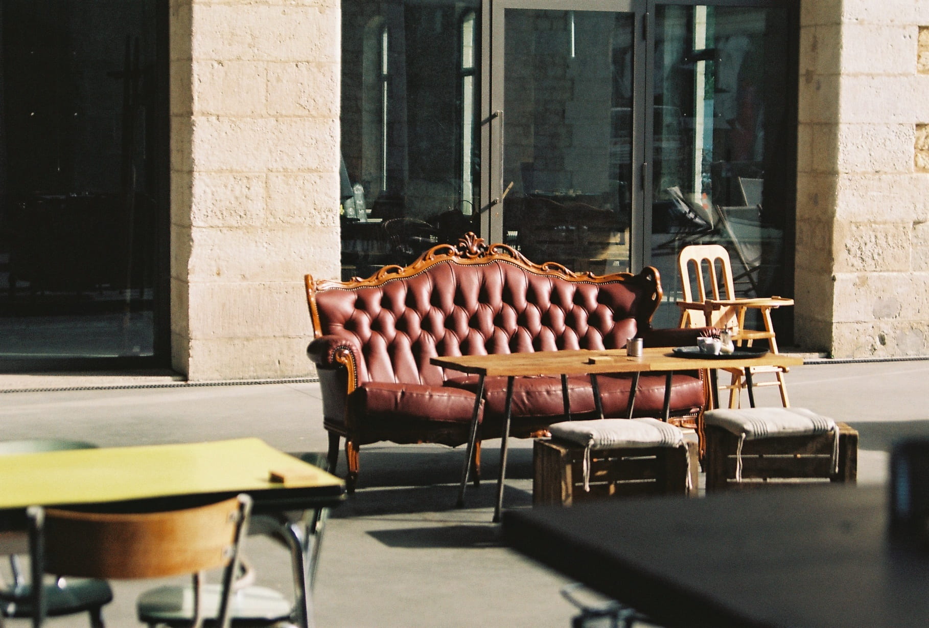 brown leather sofa outside beige building, couch, table, chairs