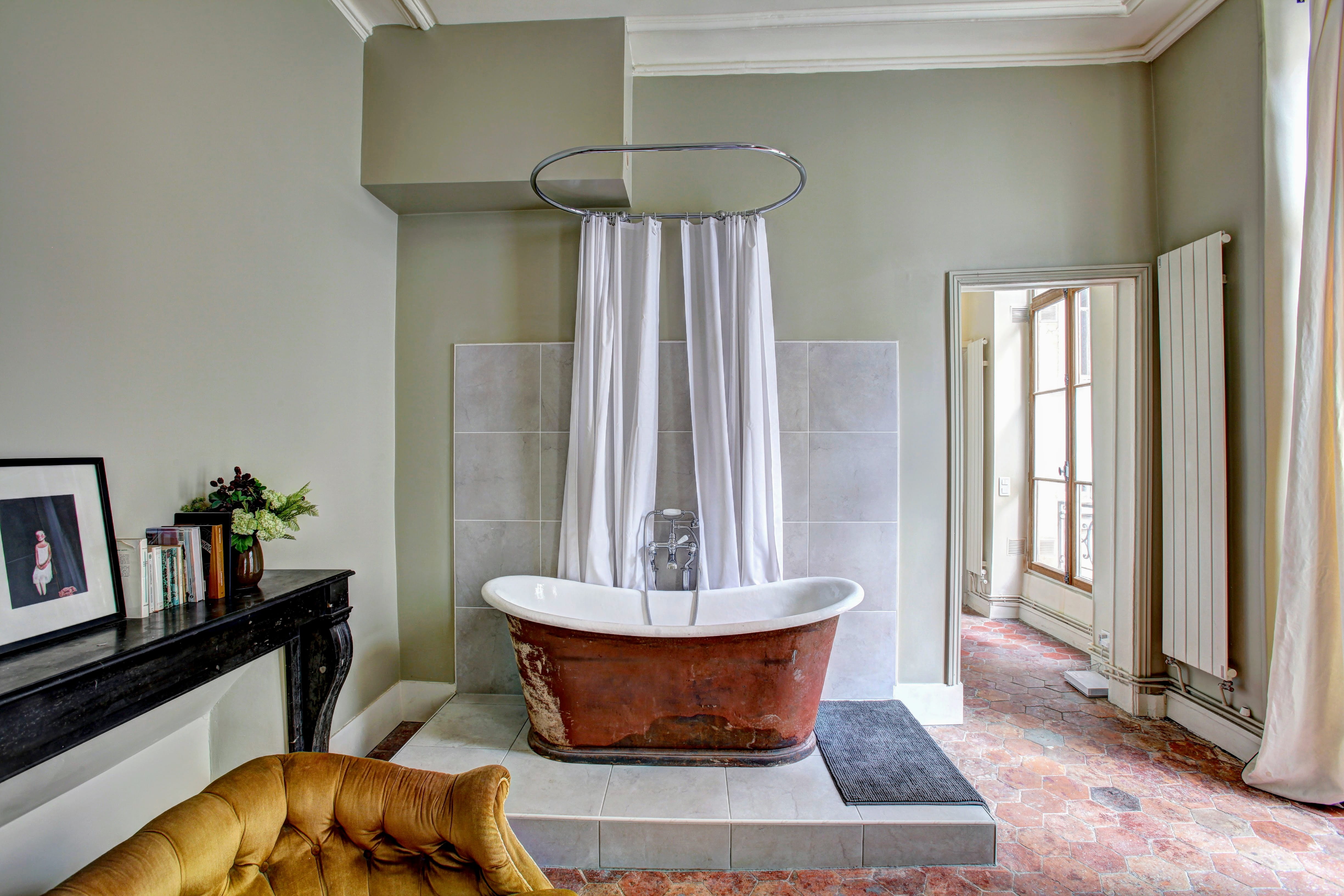 the parisian bath tub, white and brown bathtub beside curtains