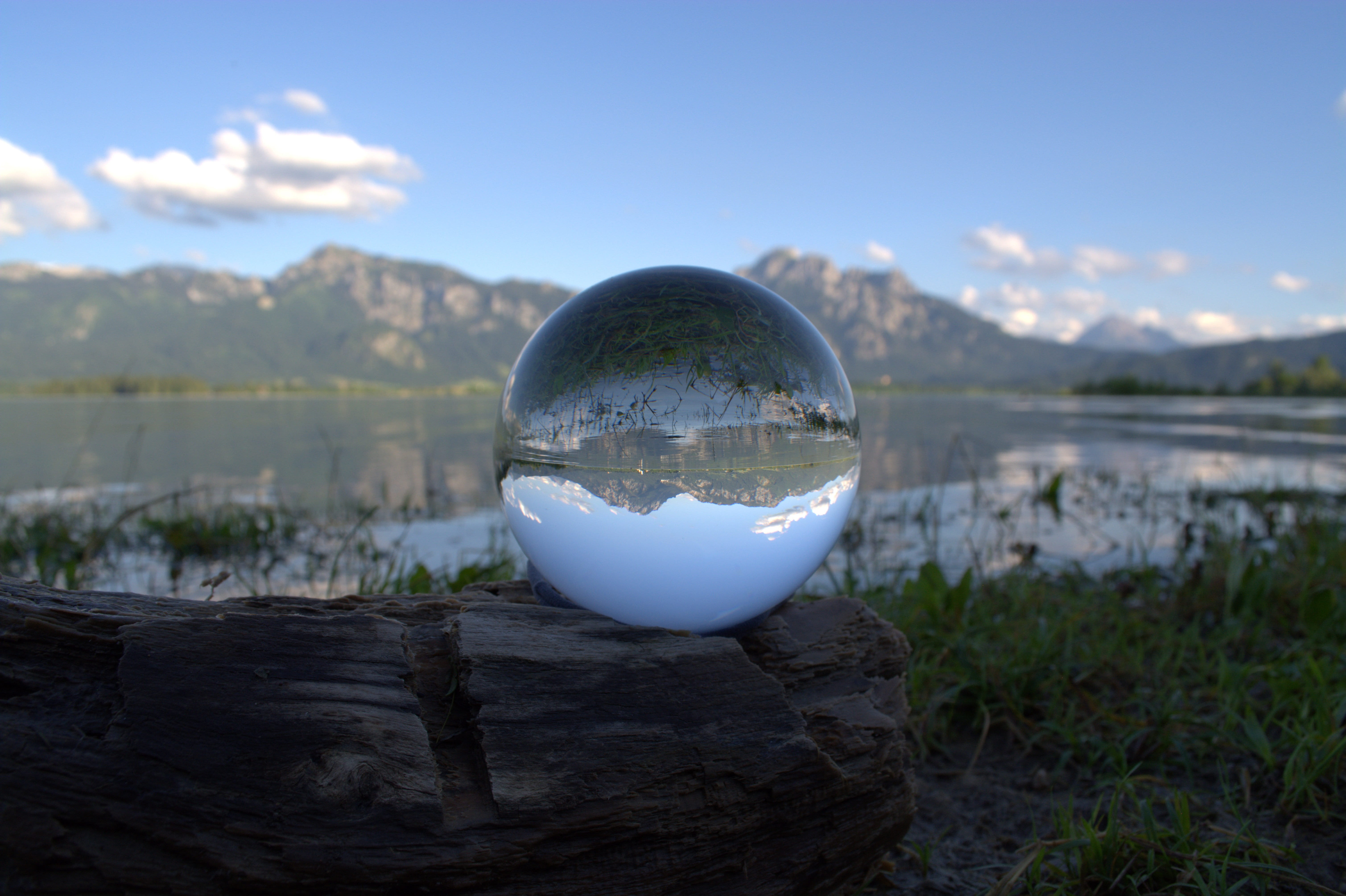 white glass ball on brown wood, globe image, alpine, panorama