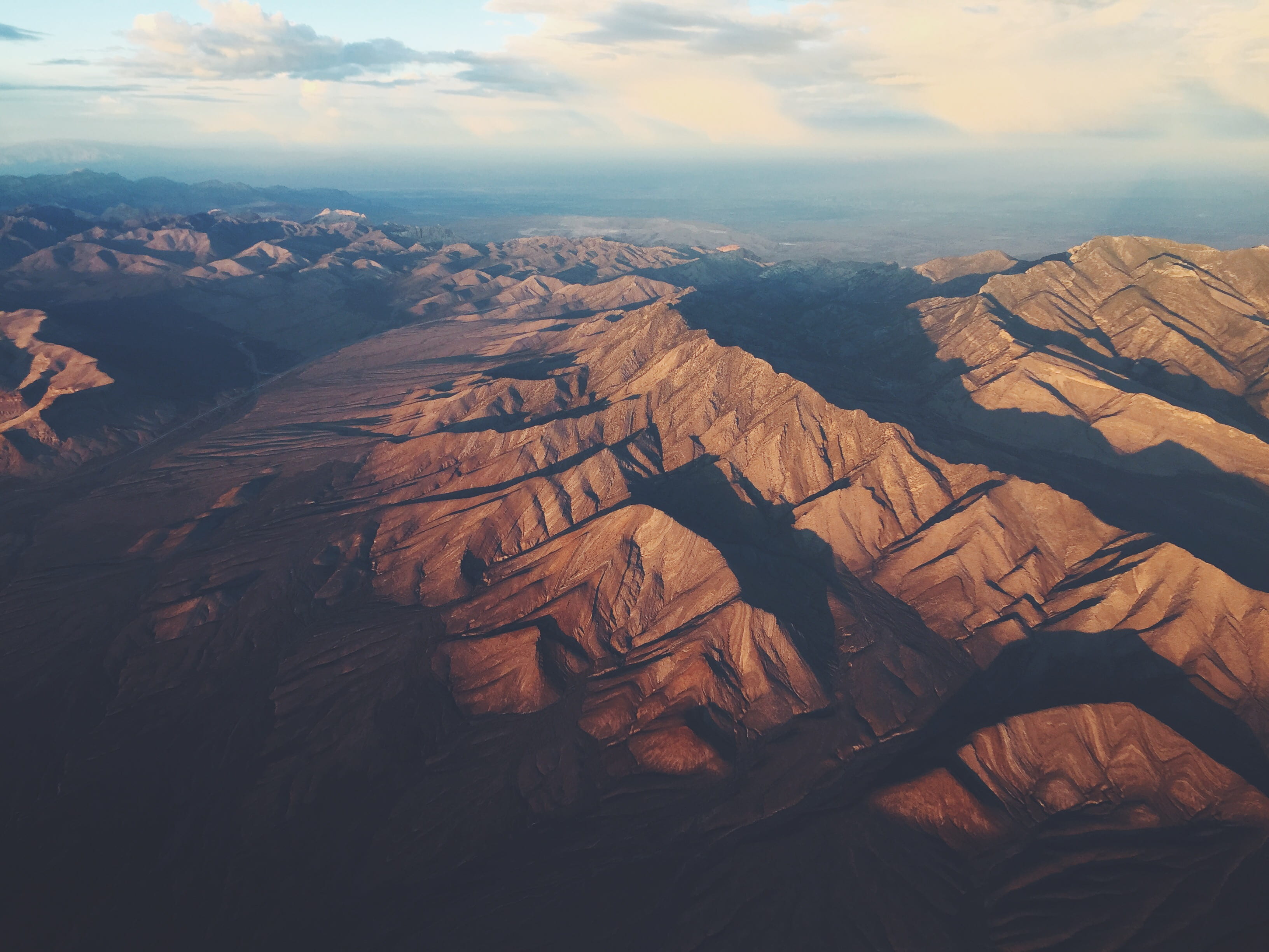 brown mountains under white clouds during daytime, mountain range