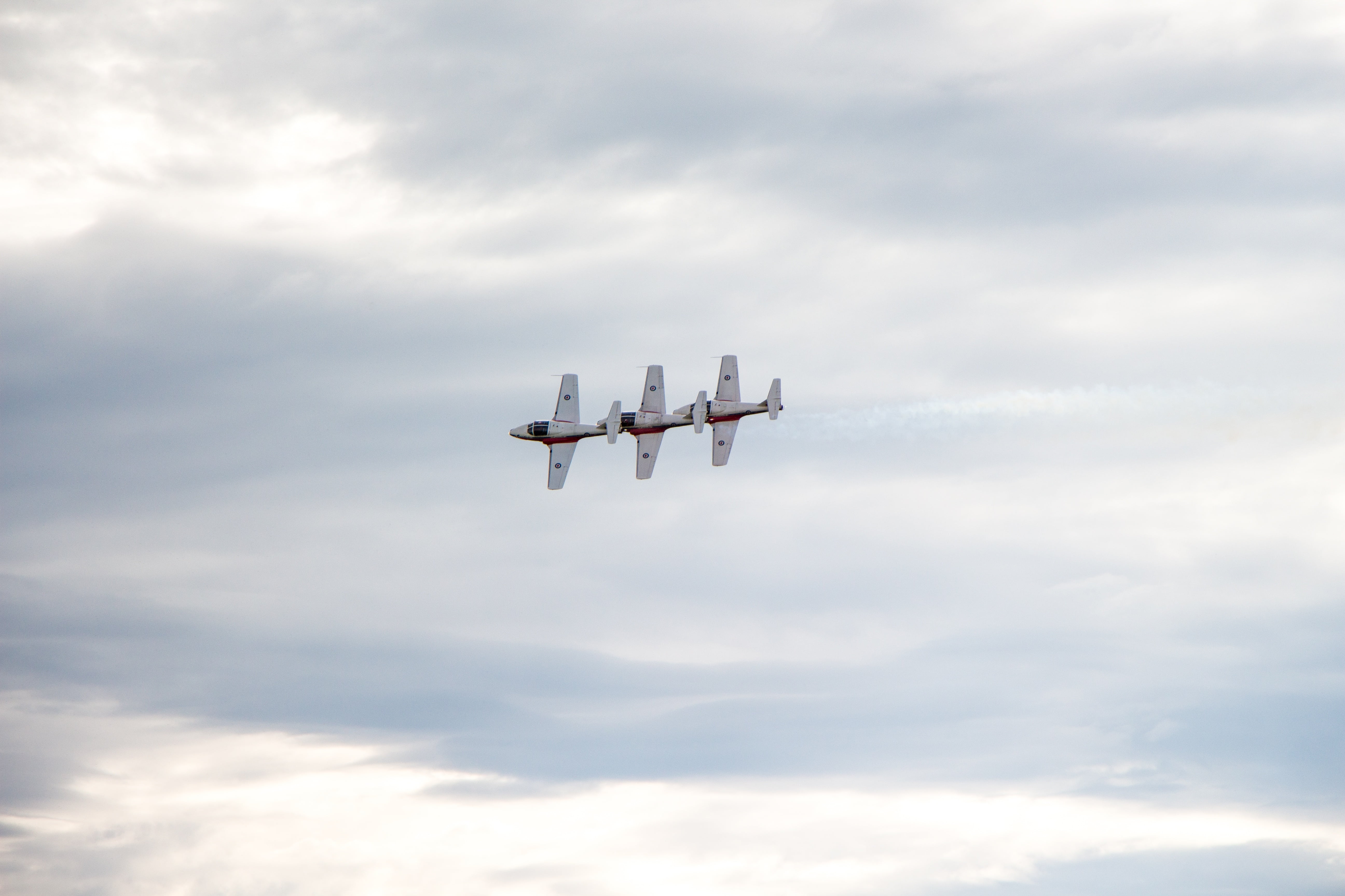 three flying white planes under cloudy sky during daytime, snowbirds