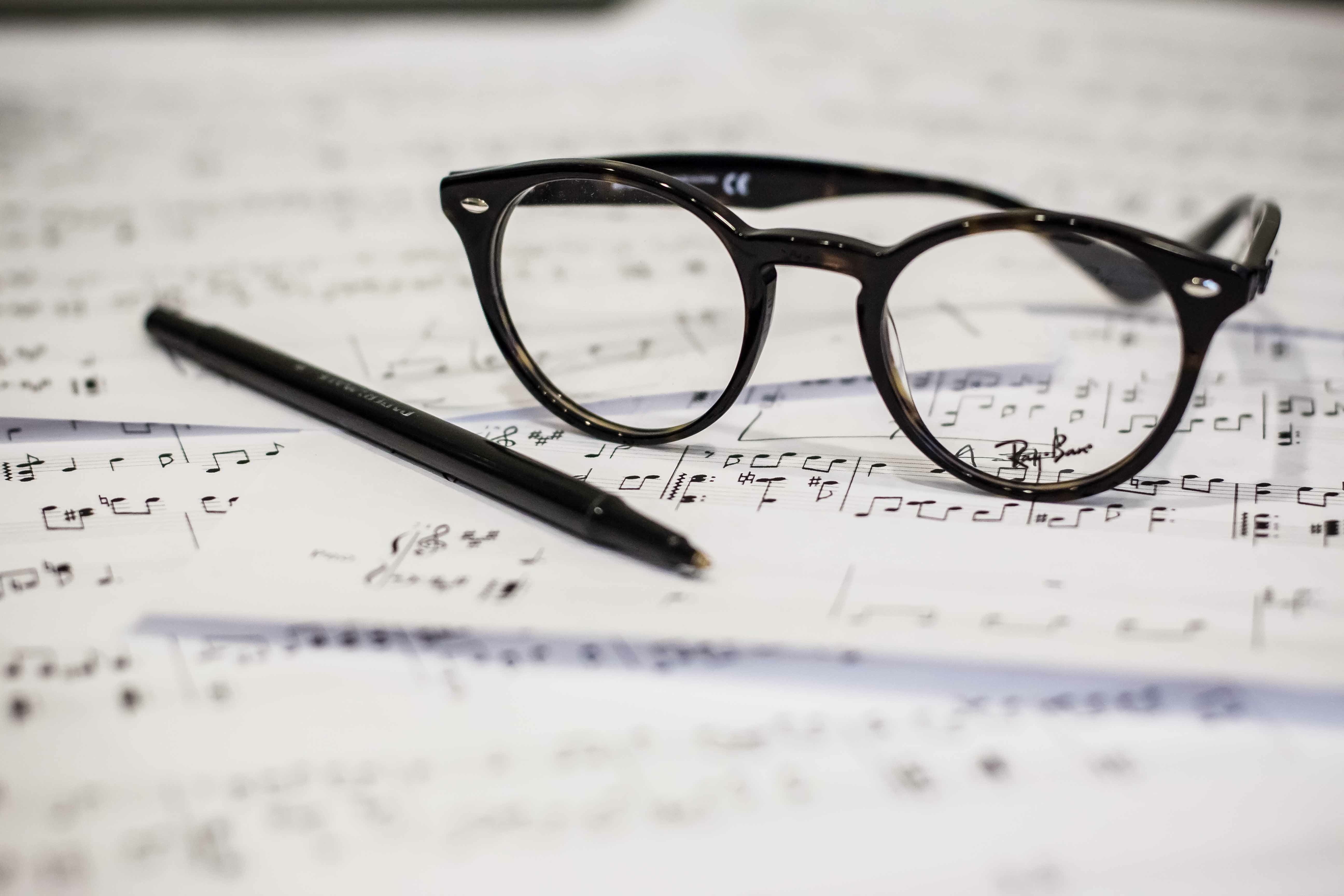 black framed eyeglasses beside black pen, music, sheet music