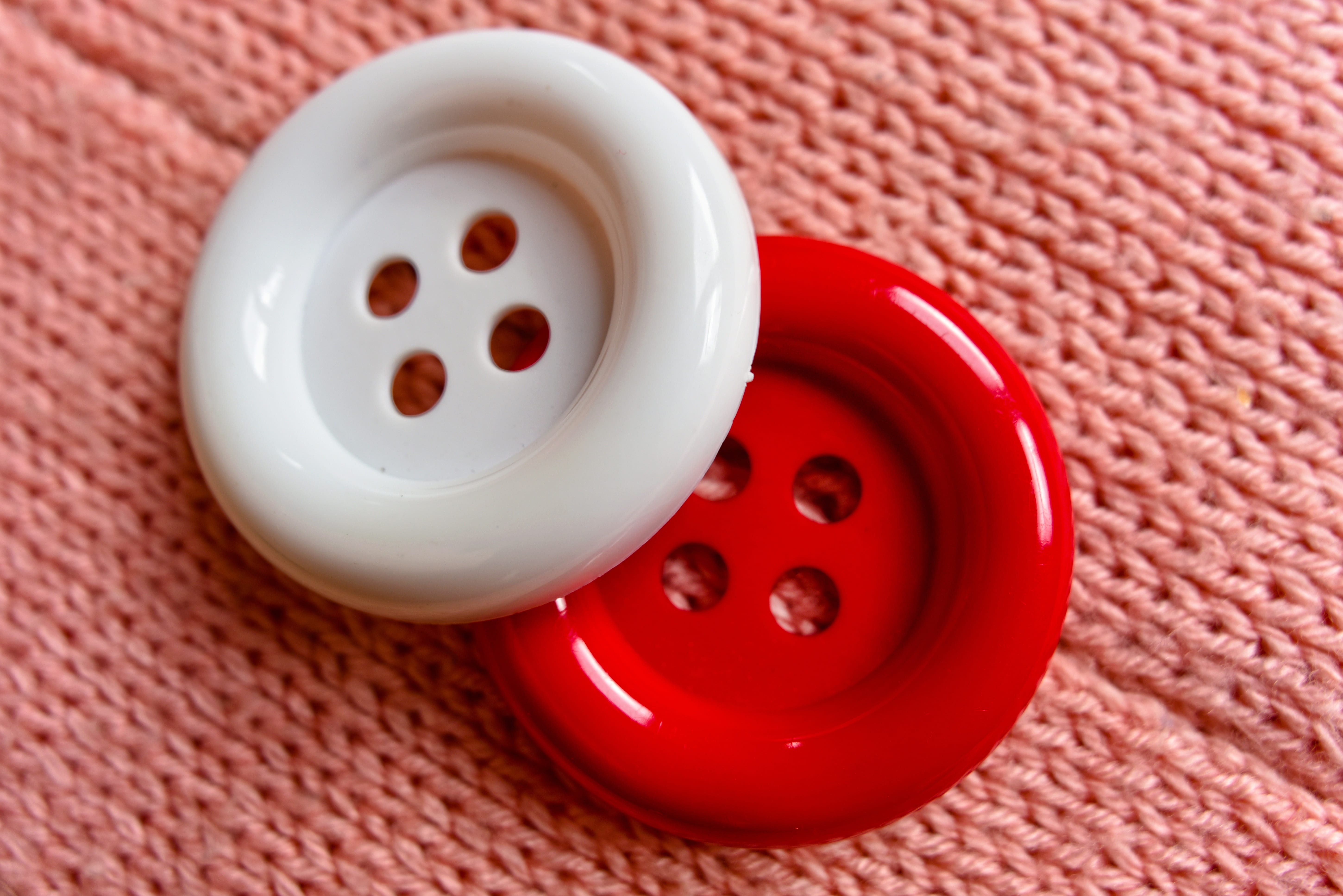 white and red clothes buttons on pink textile, fasten, button hole