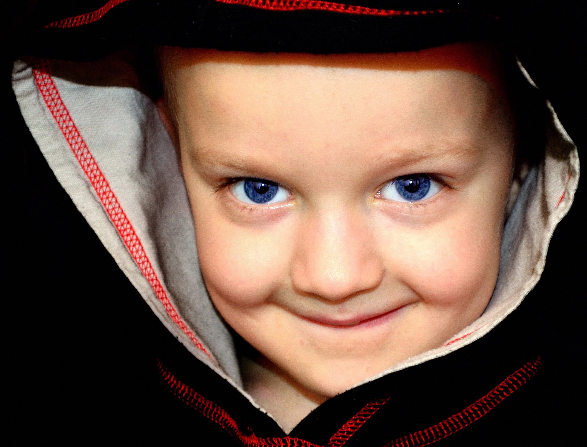 toddler wearing black and red hoodie, blue, boy, eyes, look, people