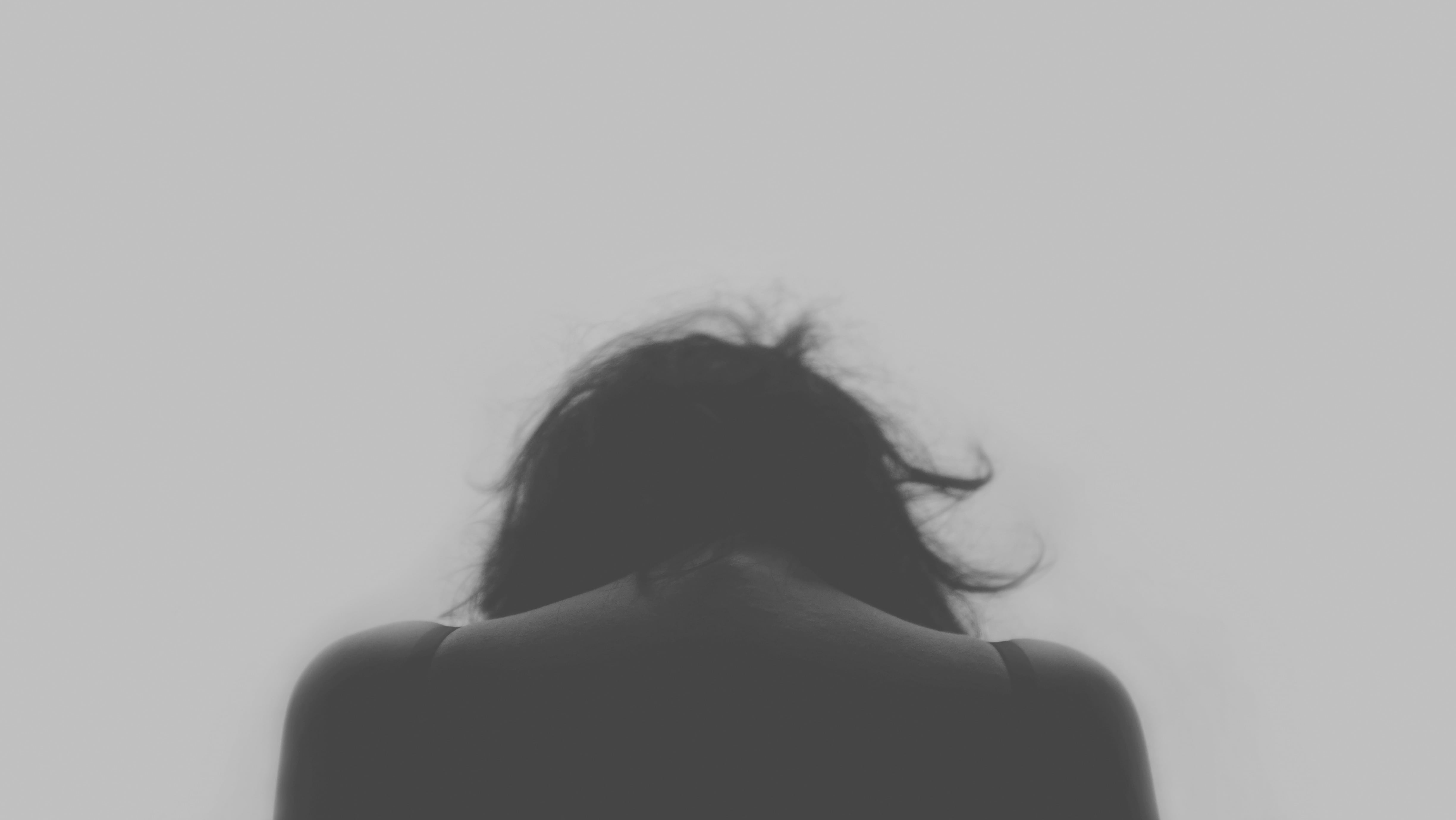 woman facing towards white background, sad, depressed, depression