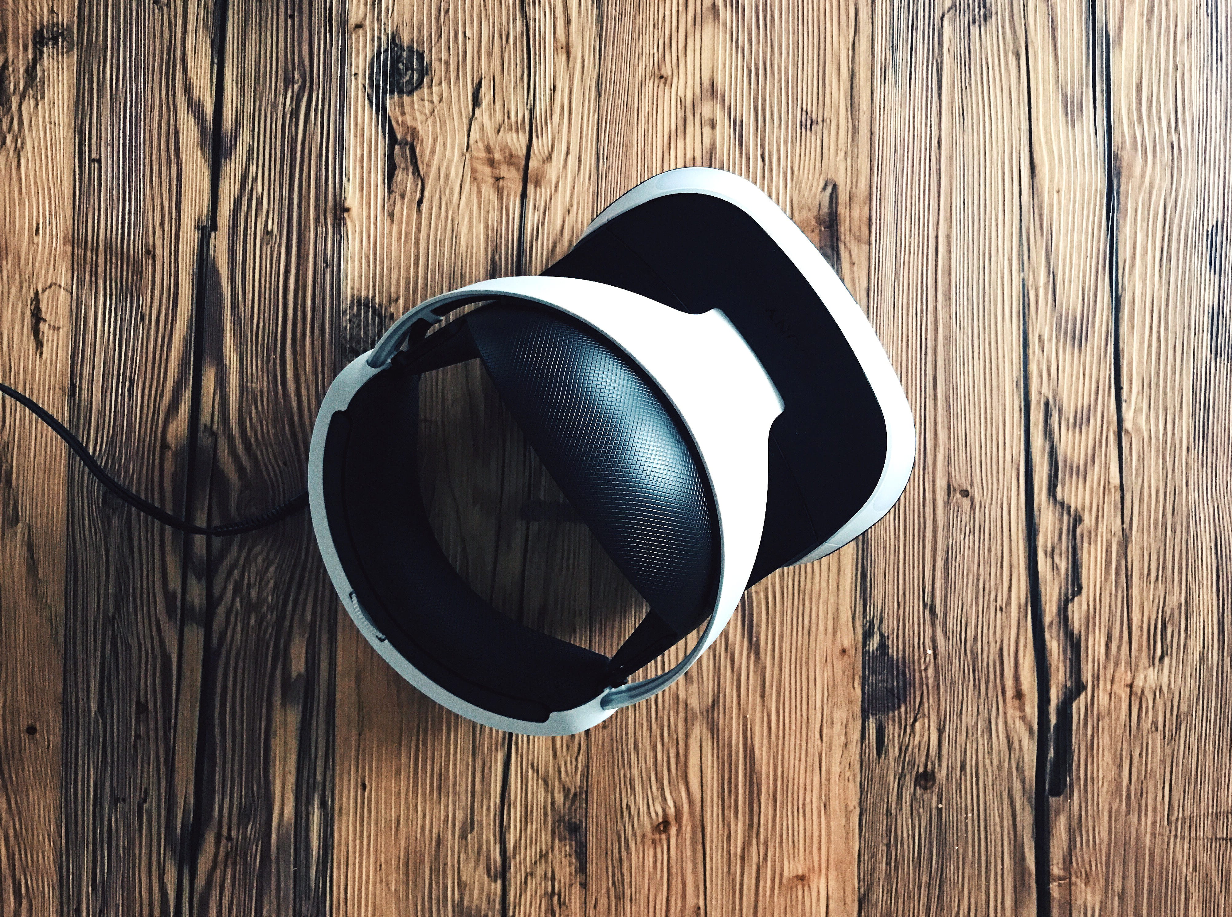 white and black Bluetooth headphones, white and black Sony PS4 VR hearset