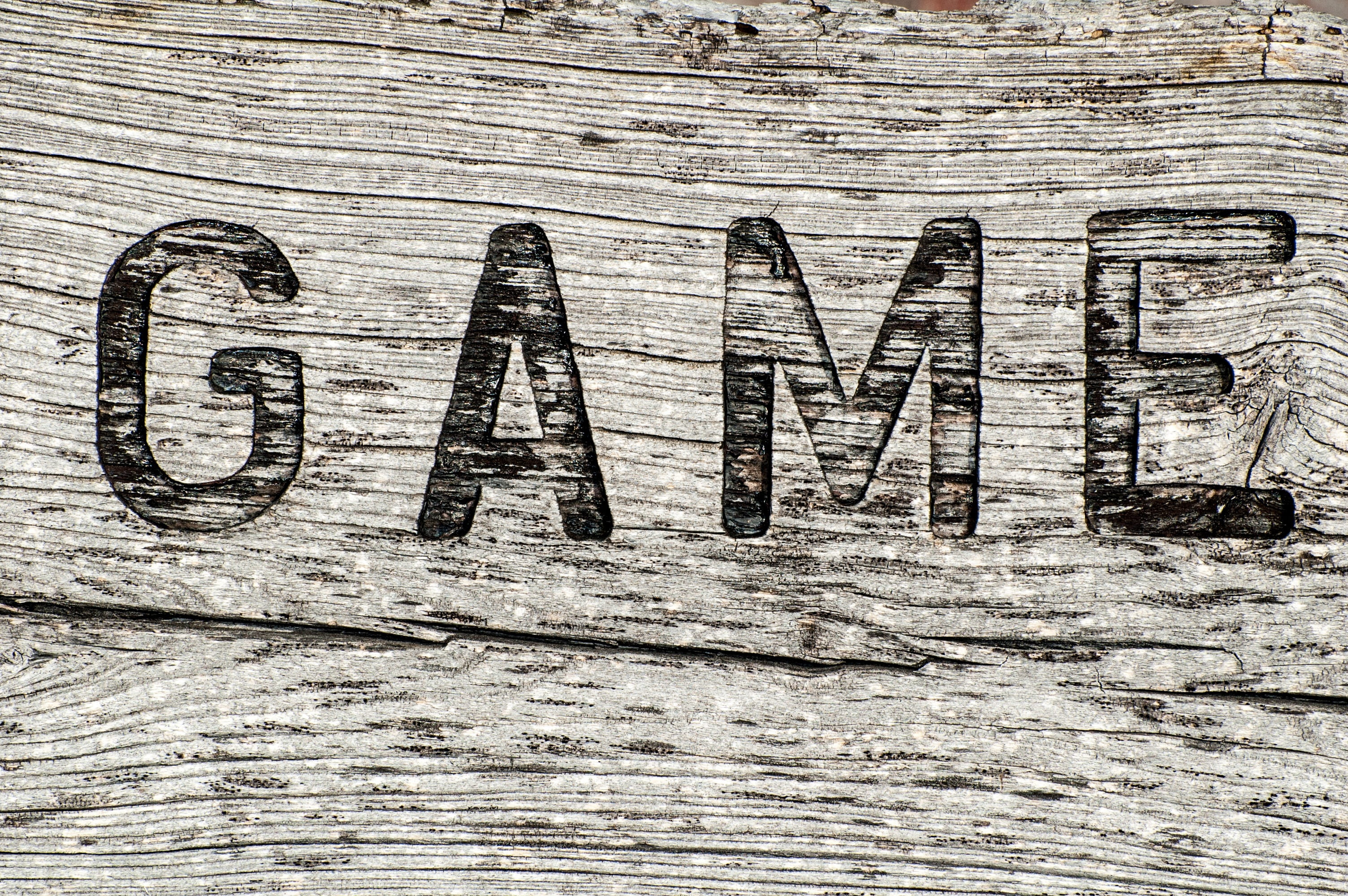 gray background with game text overlay, wooden sign, rustic, weathered