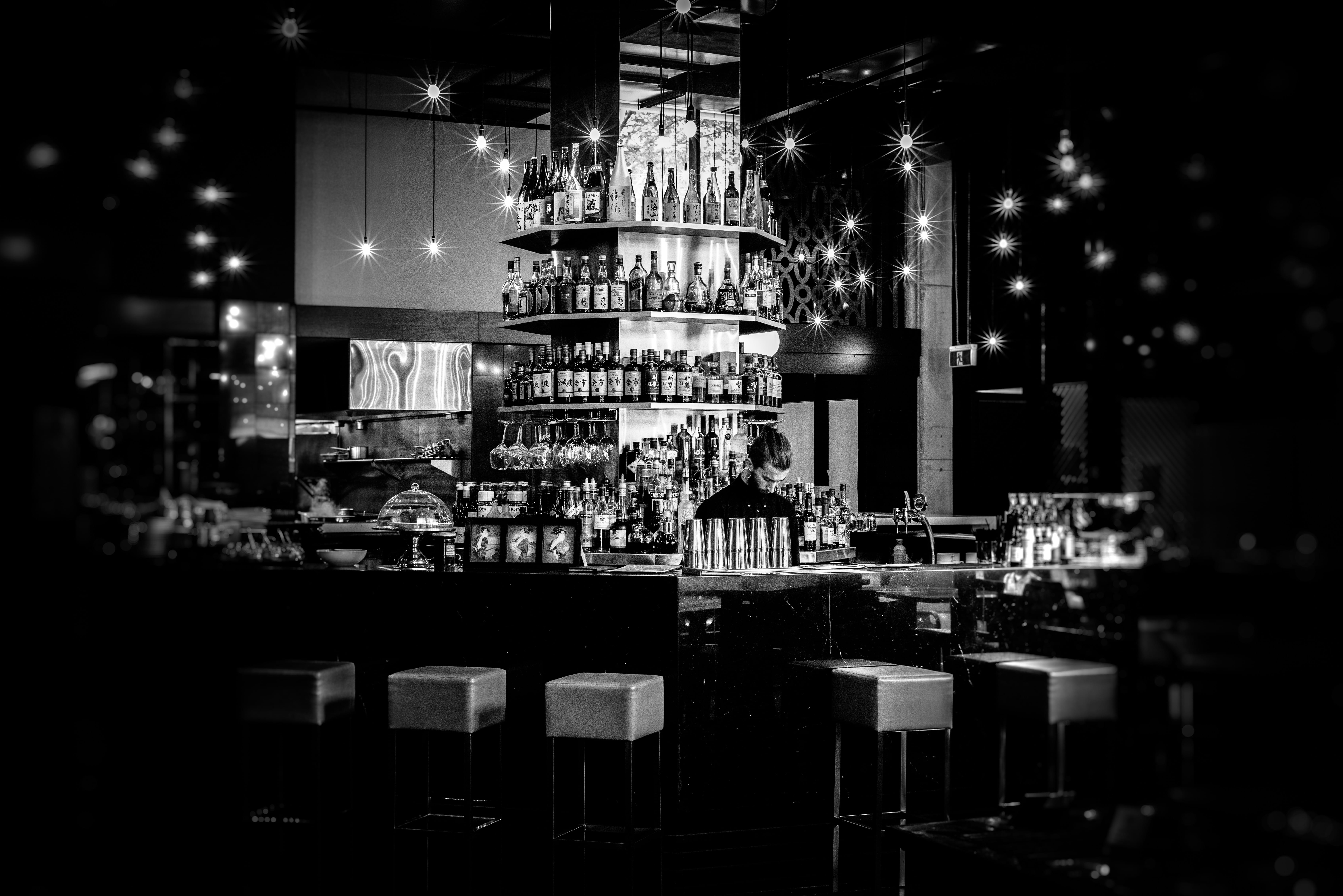 grayscale photography of resto bar, pub, wine glasses, lighting