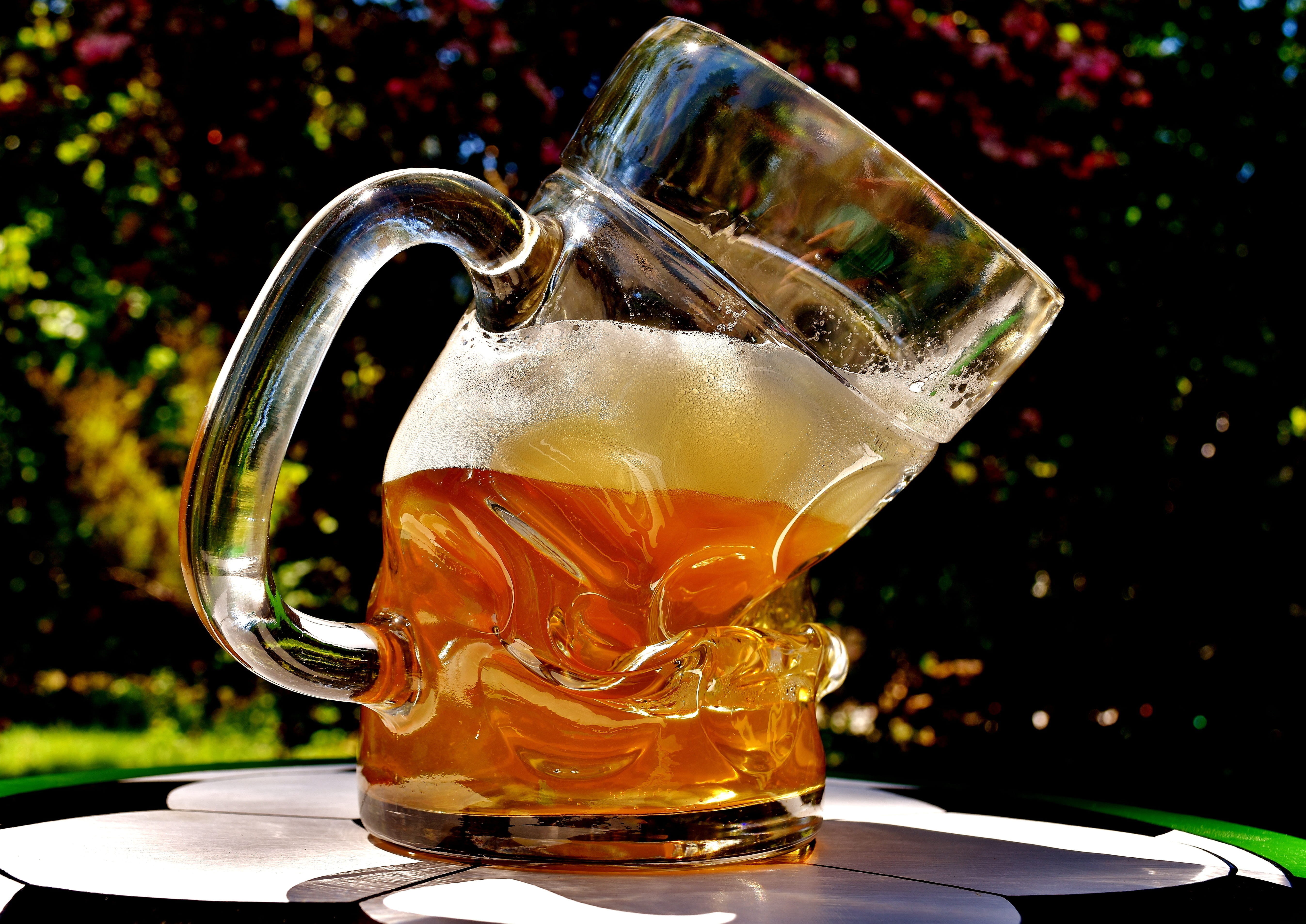 clear glass beer mug filled with beer, beer glass, deformed, bent