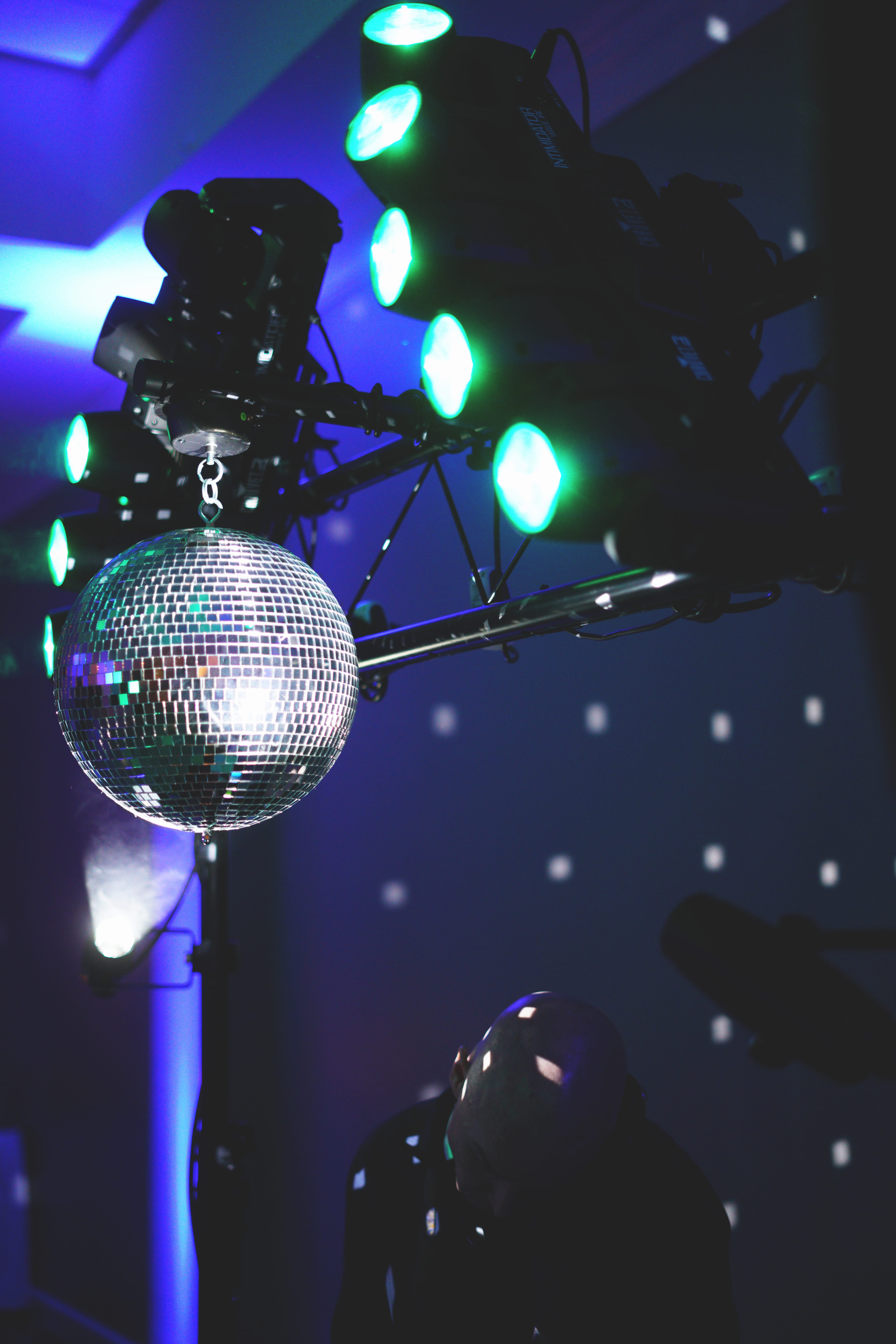 silver disco lights, person near the mirror ball, DJ, mirrorball