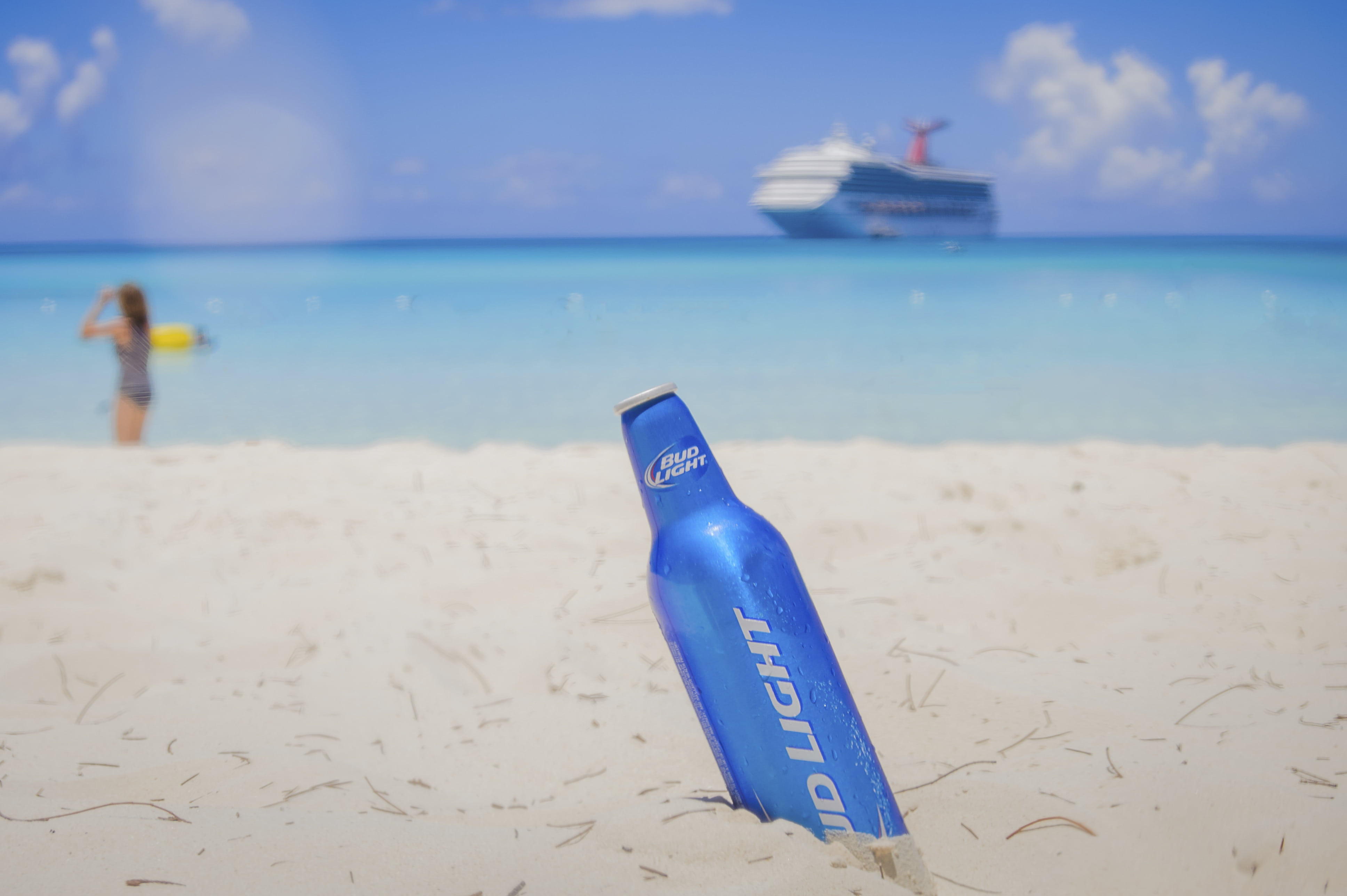 blue Bud Light on white sand by the seashore, selective, photography