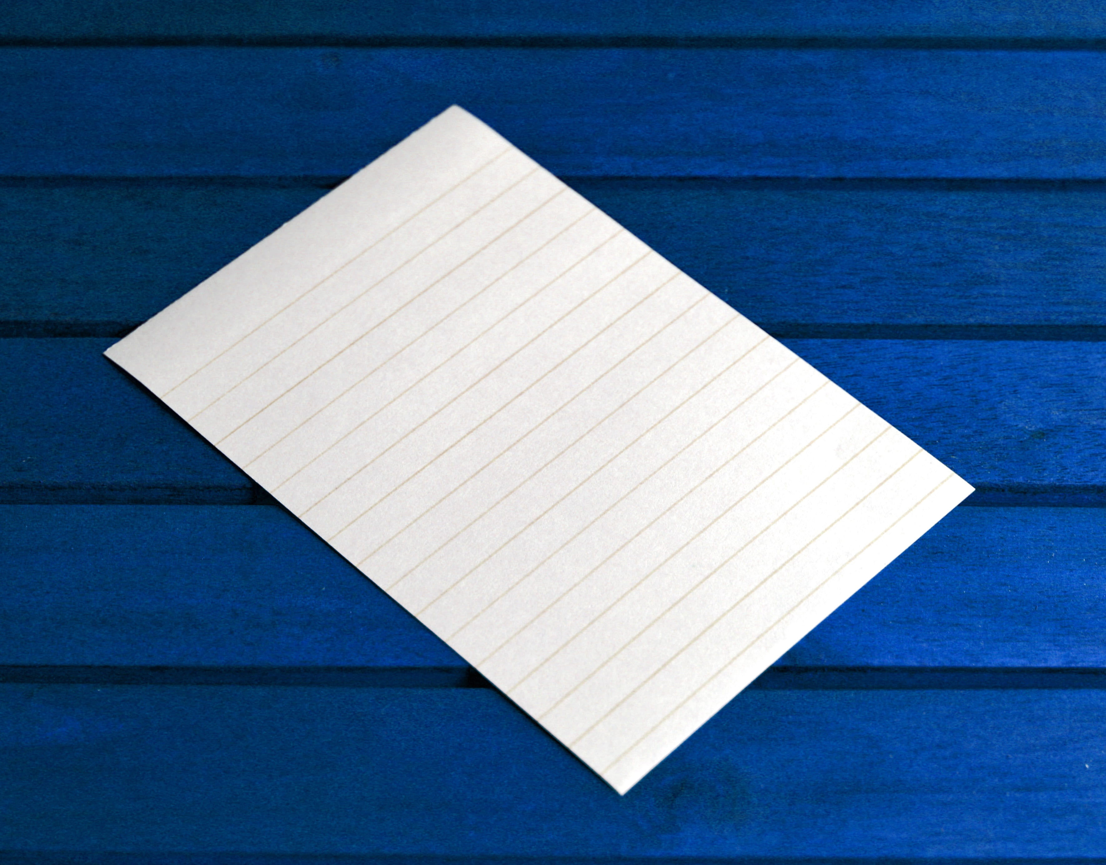 empty white lined paper on blue surface, post it, notes, message