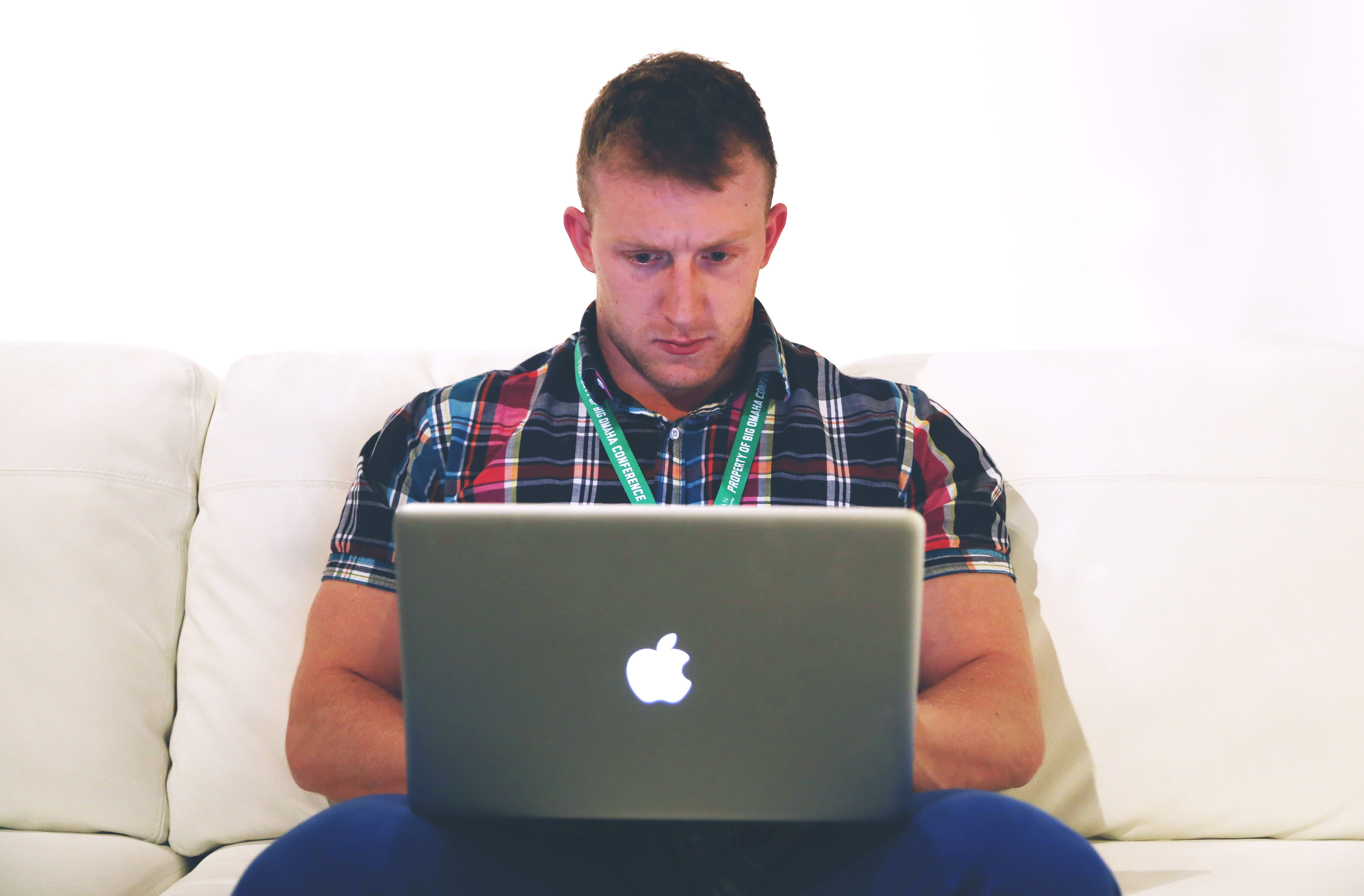 man using gray macBook on sofa, lancer, typing, notebook, laptop
