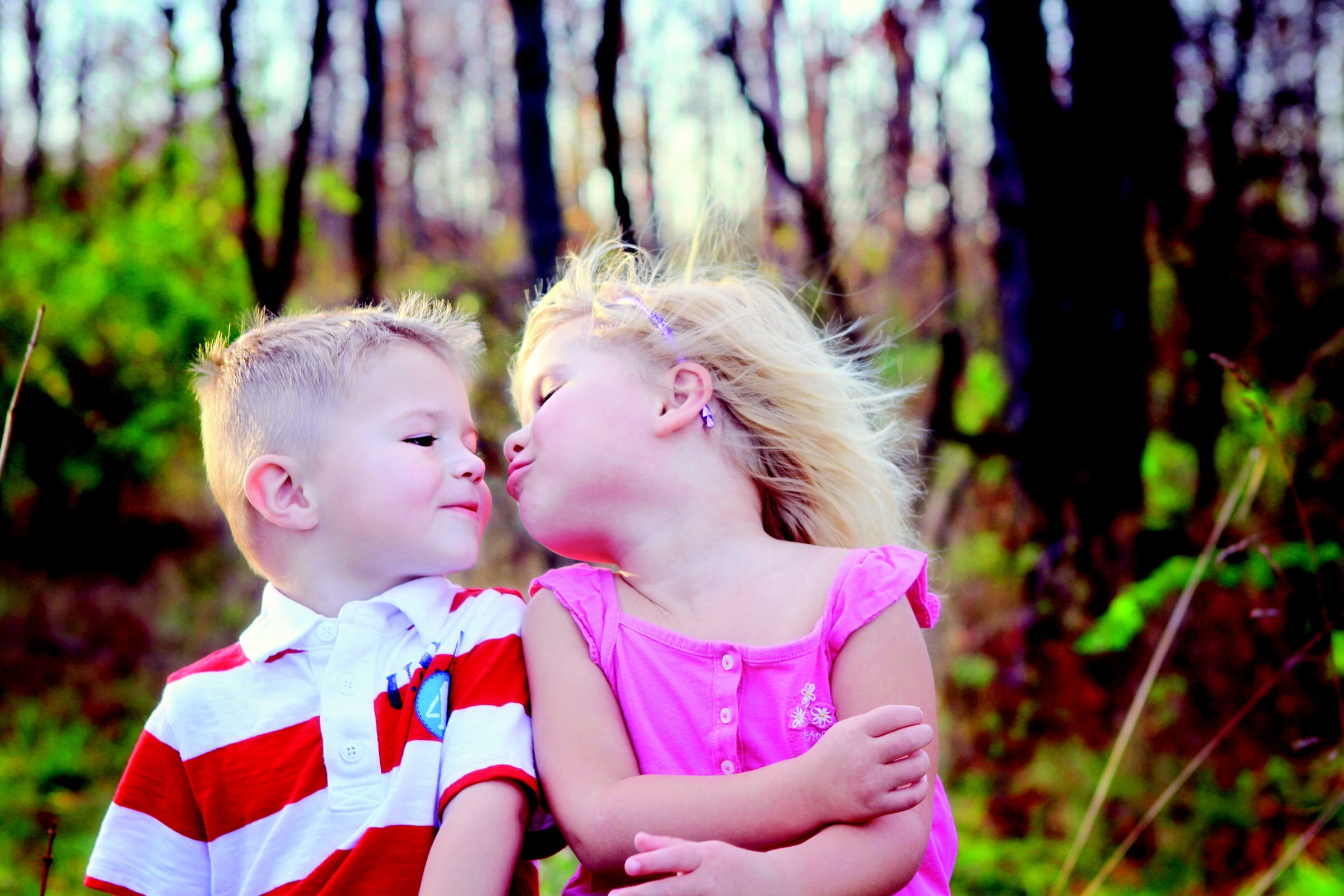 girl and boy near on green leafed plants during daytime, kiss