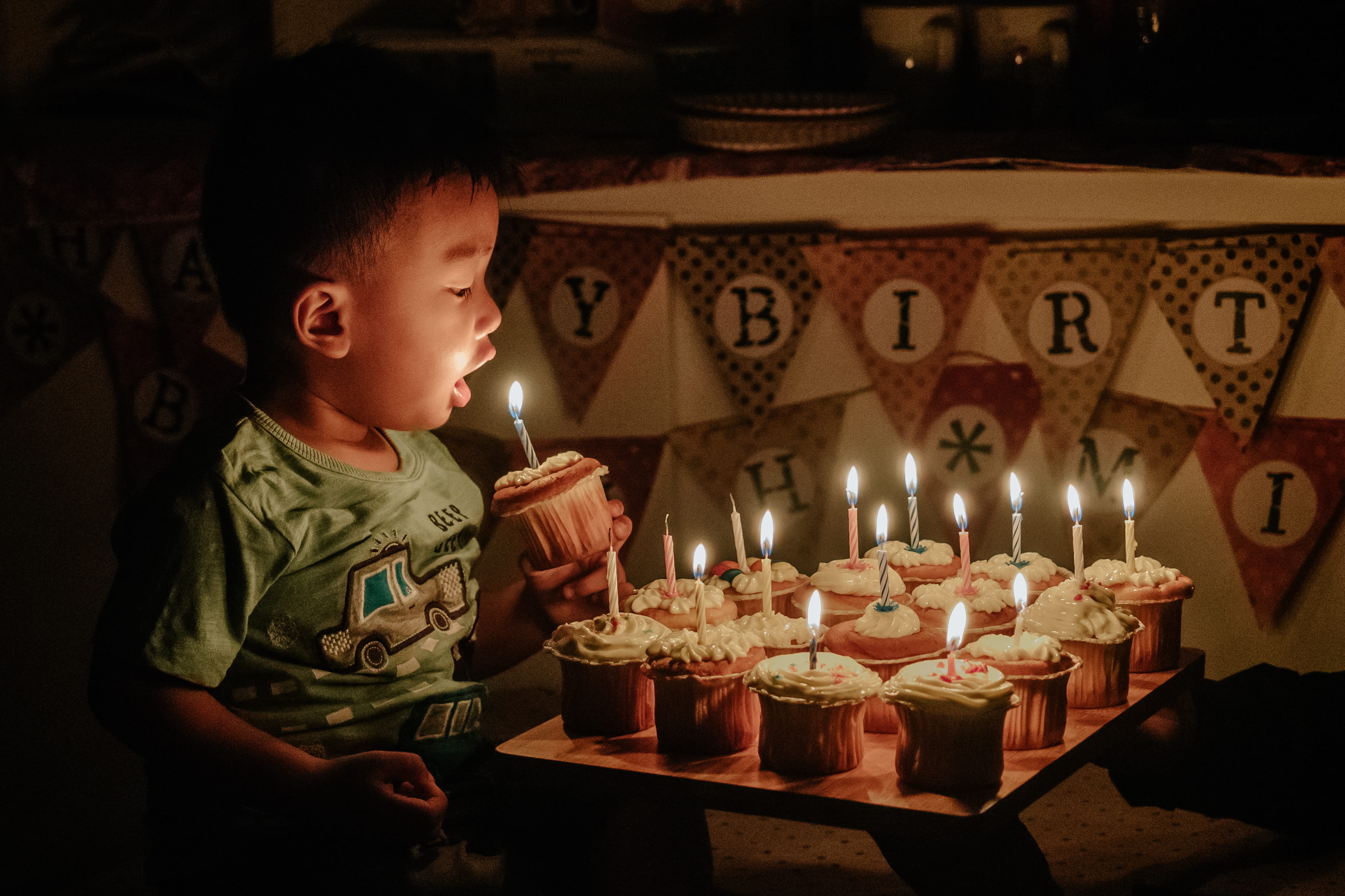 boy holding cupcake blowing the candle, boy holding cup cake