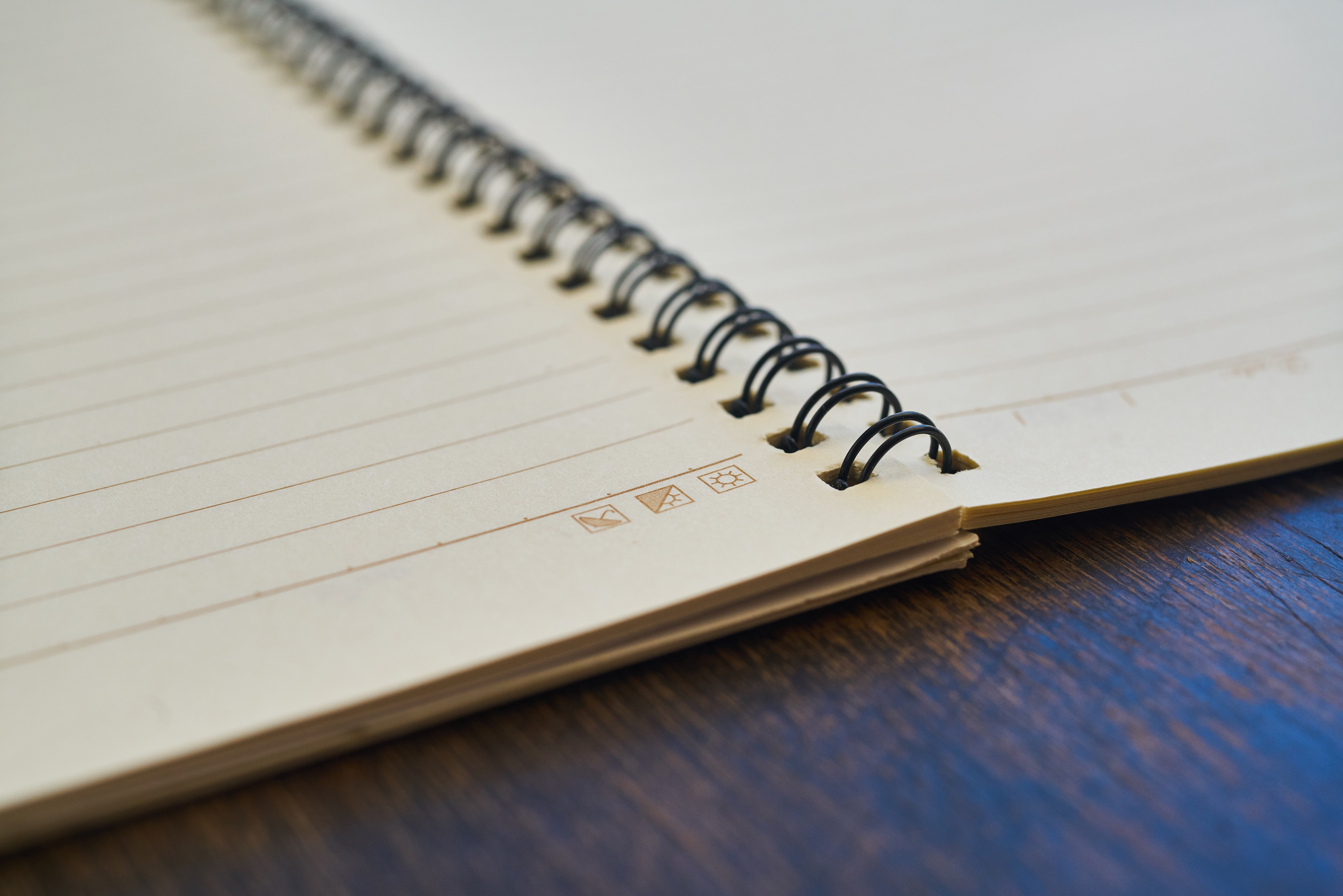 opened spring bounded notebook on brown surface, to write, work