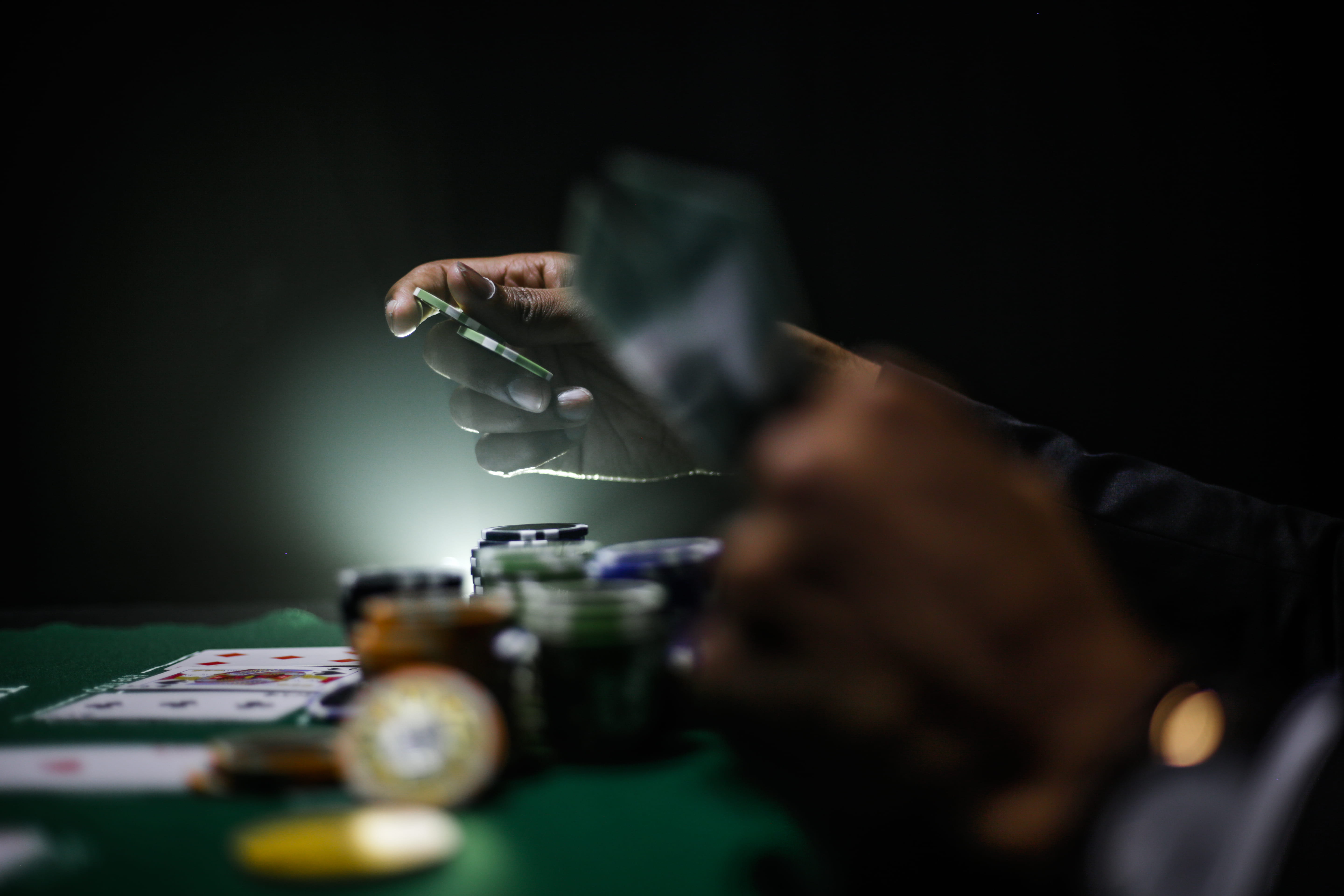selective focus photography of poker chips, person playing poker